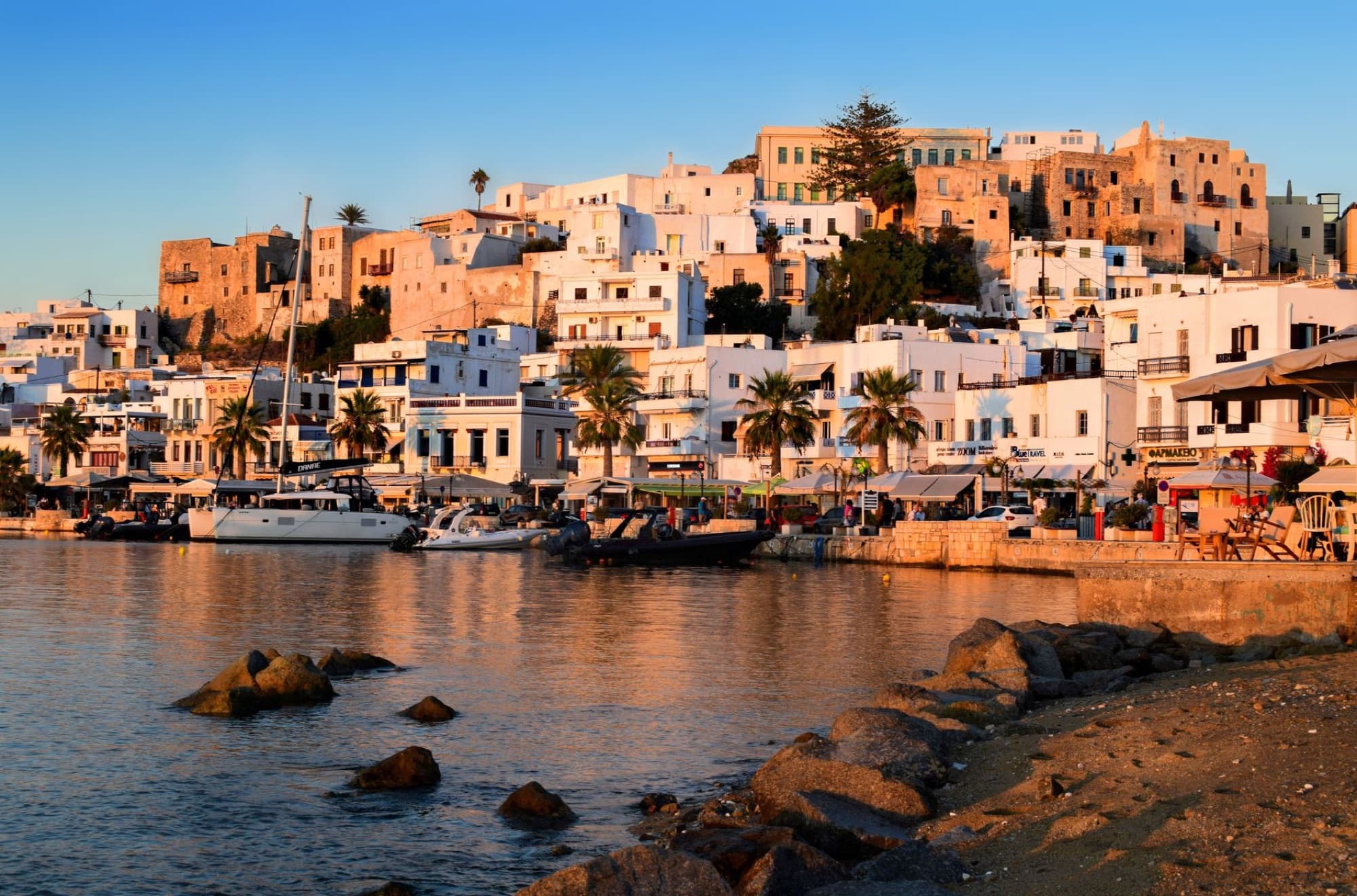 Stunning view of Naxos Town and harbor captured during sunset, showcasing traditional architecture.