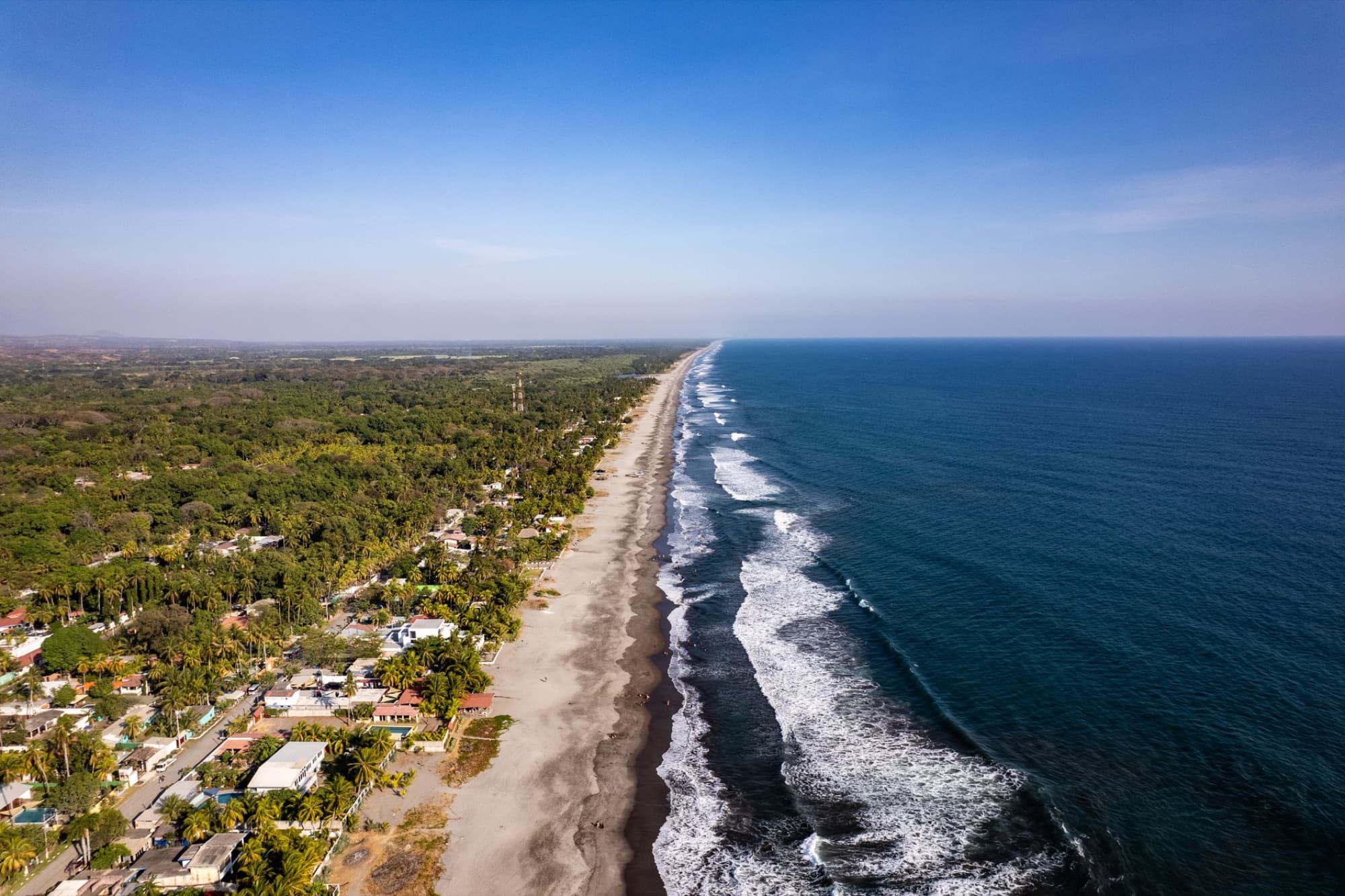Stunning aerial view of La Libertad's coastline in El Salvador, capturing the vibrant beach and surrounding landscape.