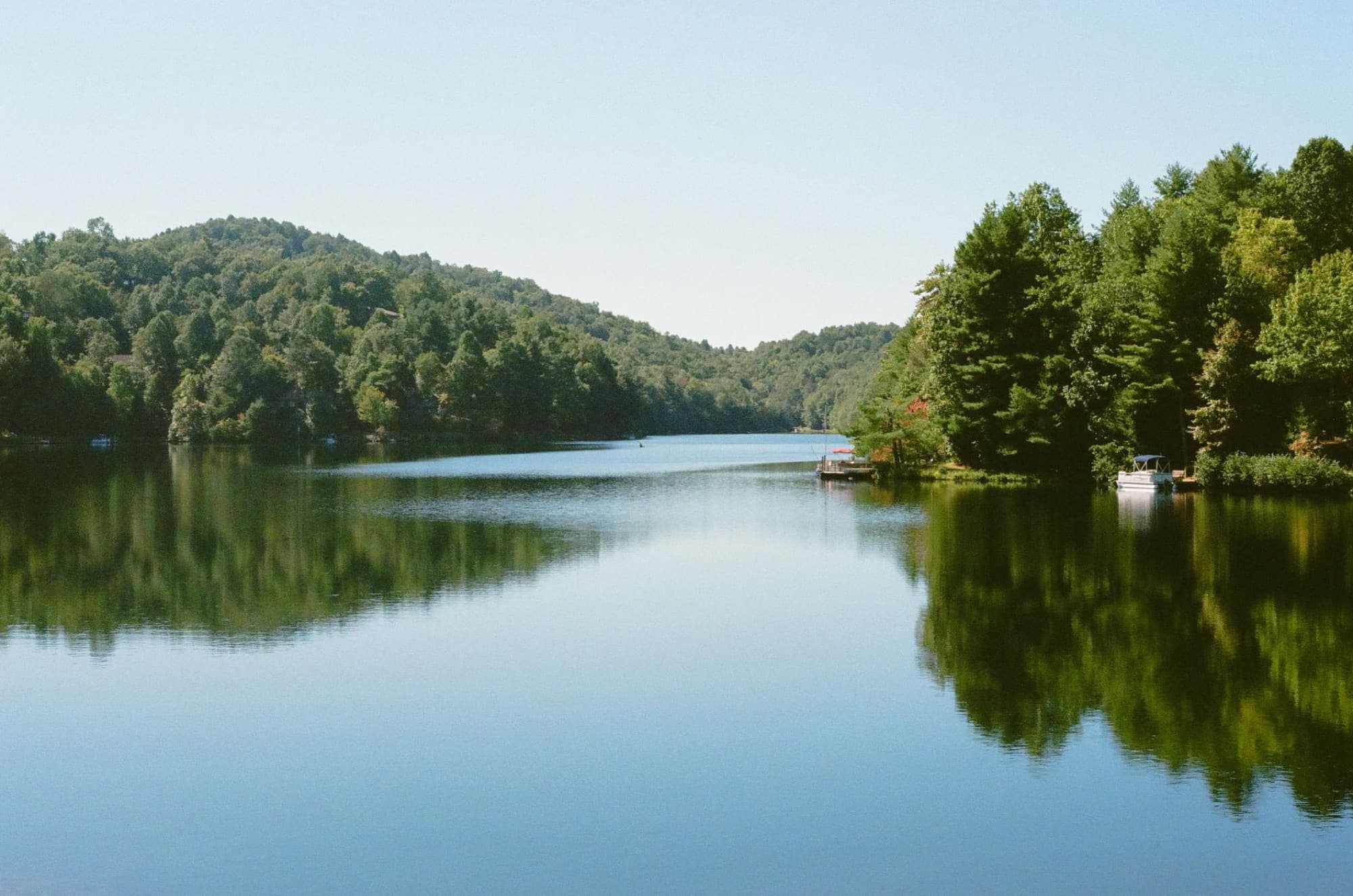 Tranquil summer scene of a lake surrounded by lush forests in North Carolina.