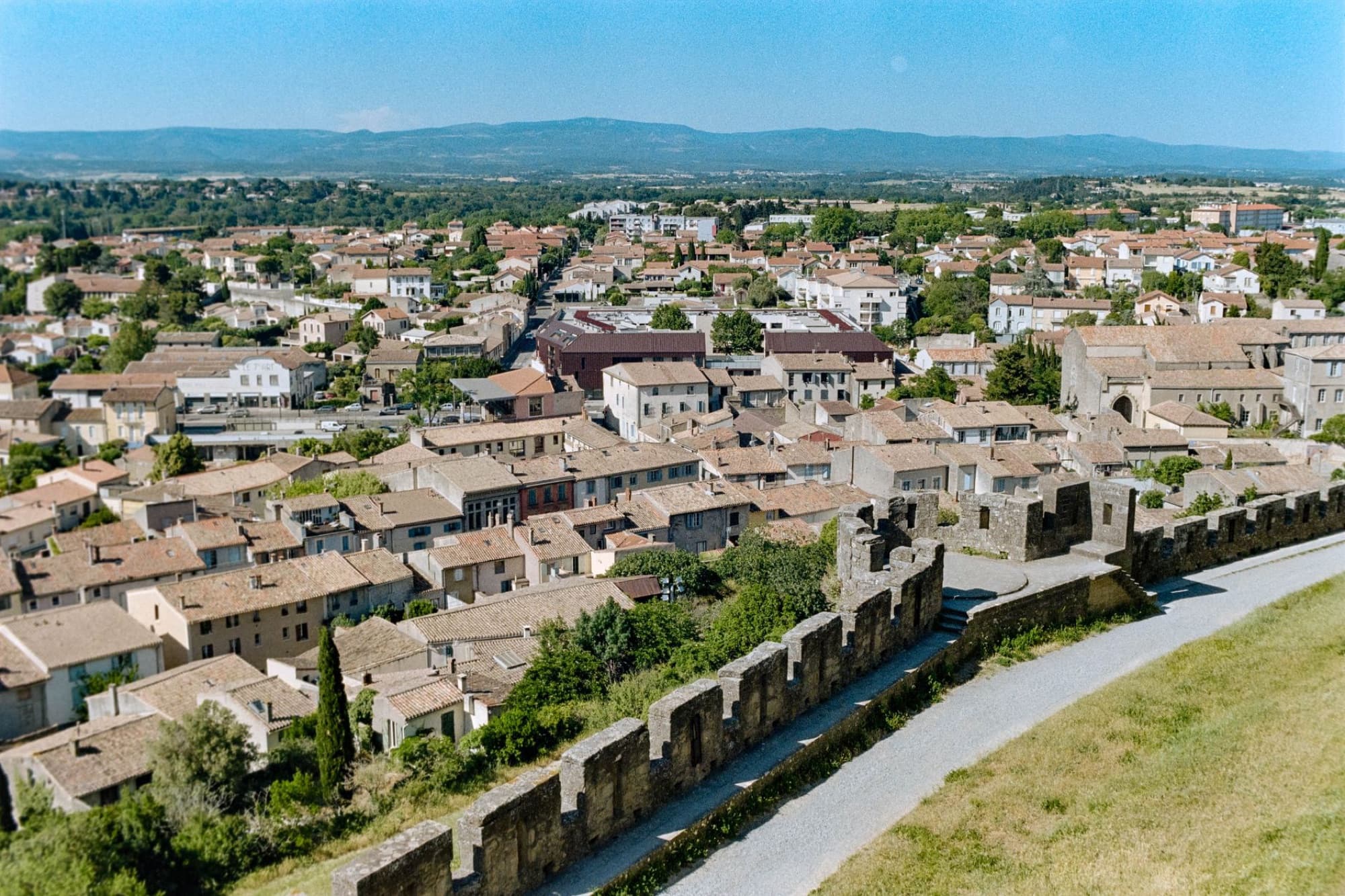 Aerial view of the historic walls and rooftops of Carcassonne, Occitanie, France on a sunny day.