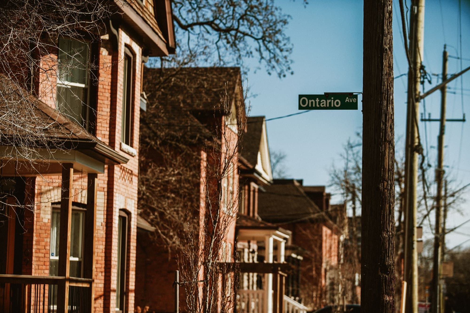 Historic brick homes on Ontario Ave in Hamilton, Canada, capturing a warm urban street scene.