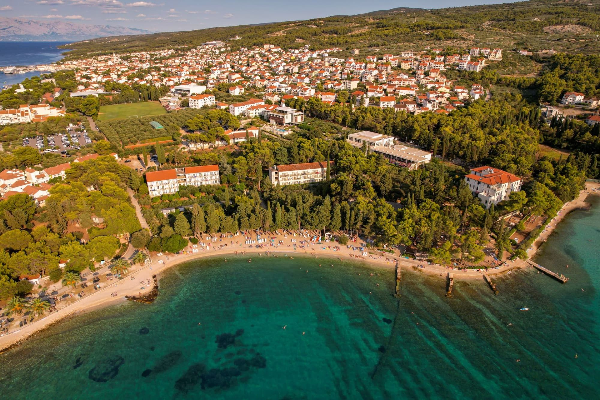 Stunning aerial view of a coastal town with a beach and lush greenery.