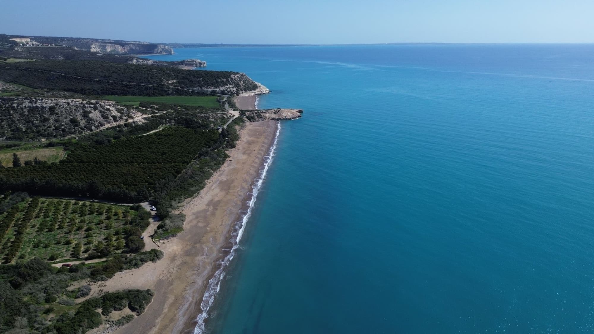 Stunning aerial shot of Pegeia beach and cliffs in Cyprus, showcasing crystal-clear waters.
