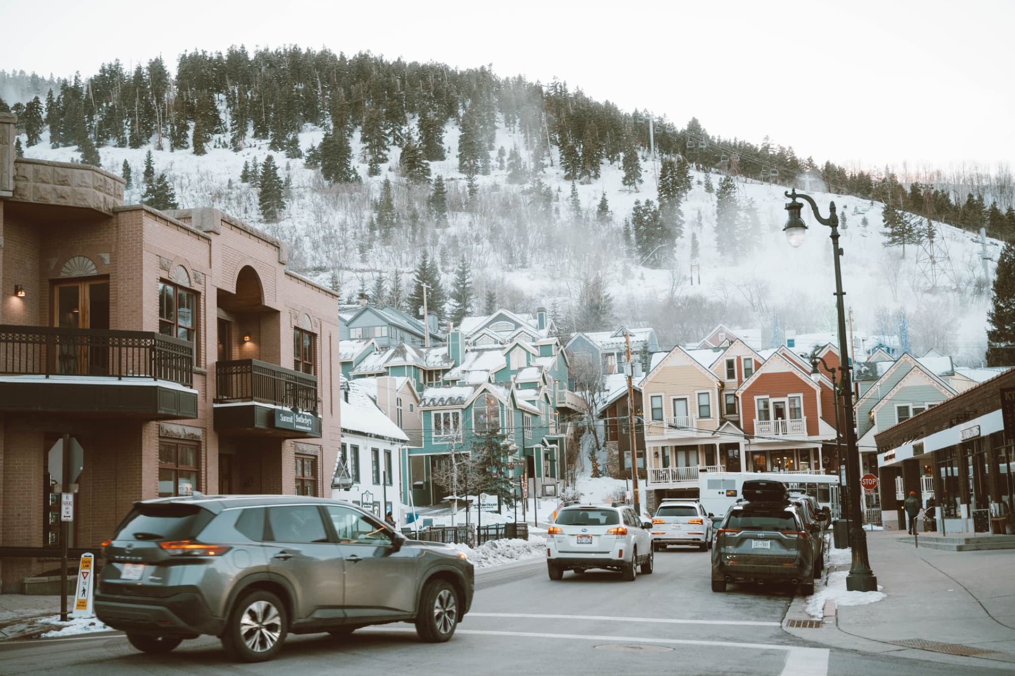 Charming winter street with colorful houses and cars in Park City, Utah.