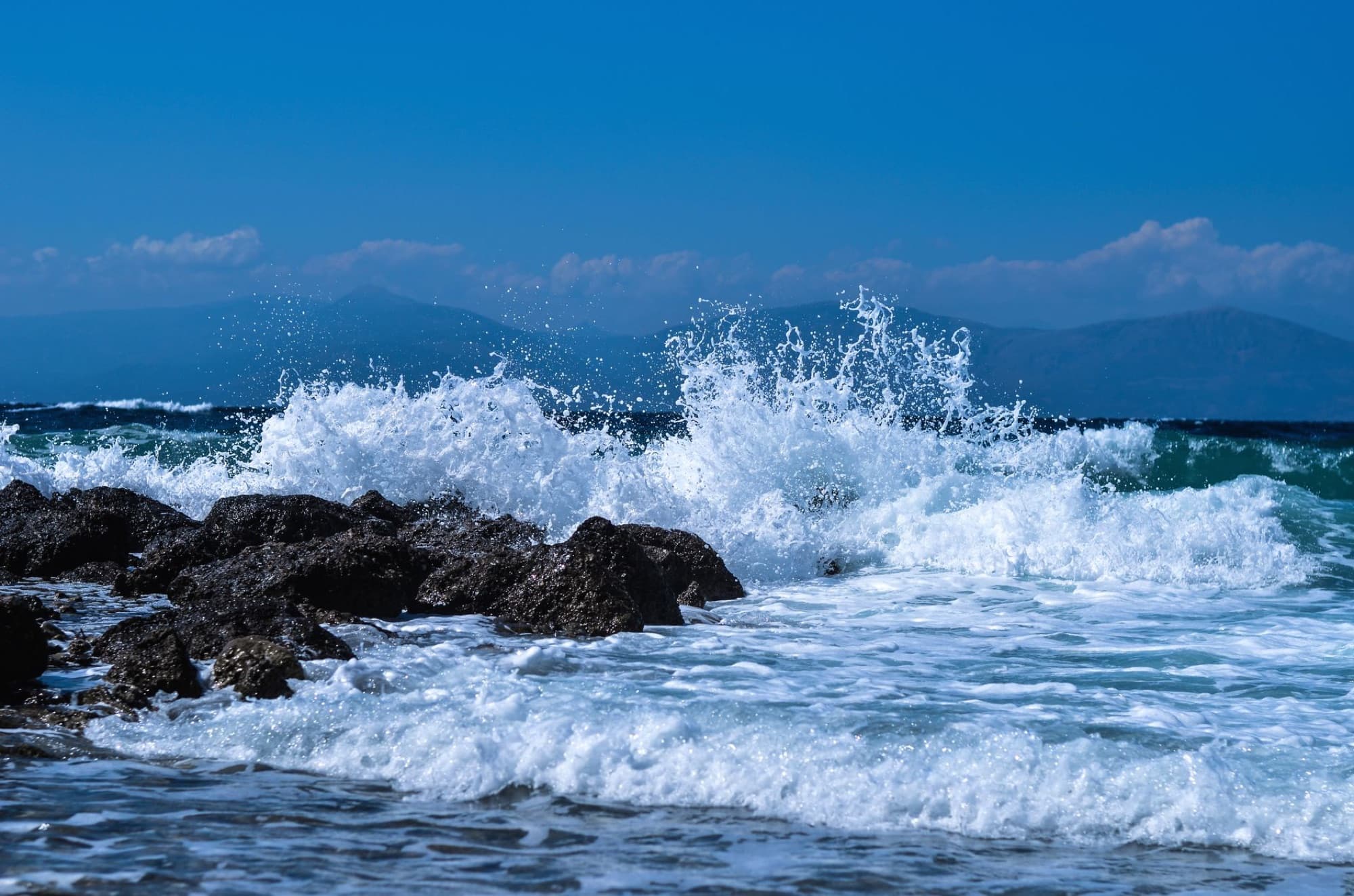 Captivating view of waves crashing on rocks along the Peloponnese coastline in Greece, showcasing natural beauty.