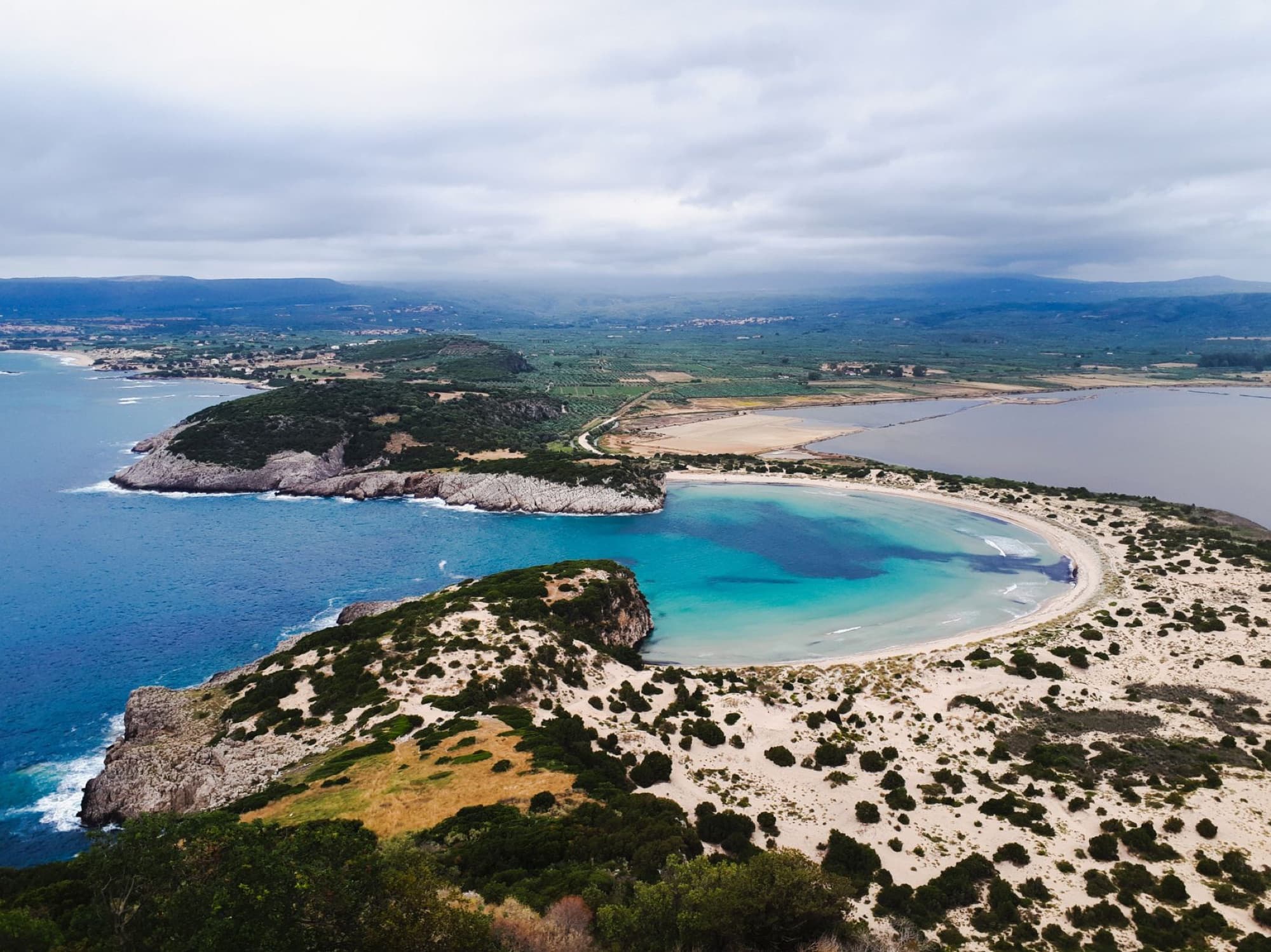 A stunning aerial view of Navarino Bay in Greece, featuring a scenic coastline and vibrant blue waters.