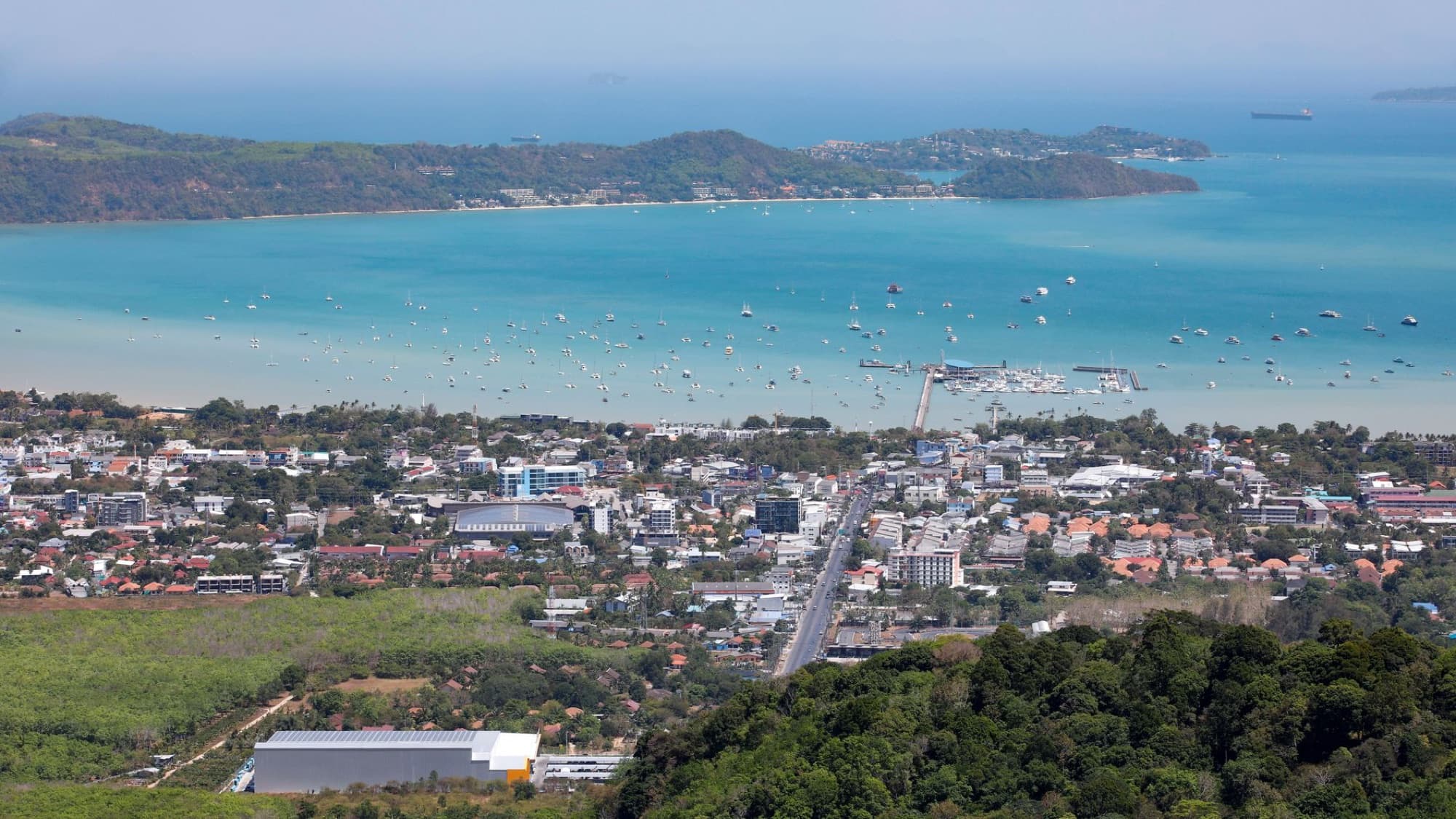 A stunning aerial view of Karon Beach, Phuket, featuring turquoise waters and urban landscape.