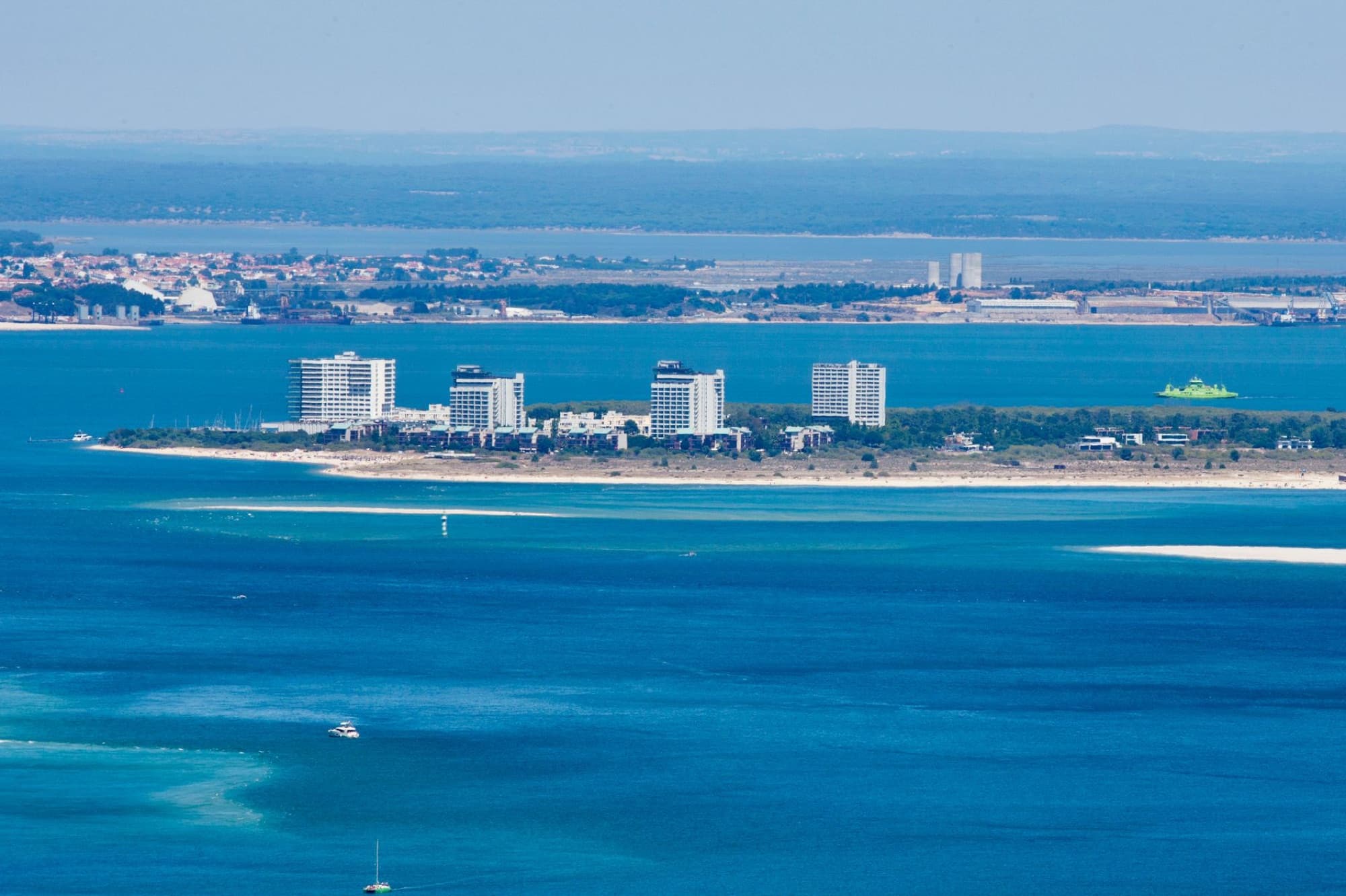 A stunning aerial view of a cityscape along the coast with vibrant blue ocean water.