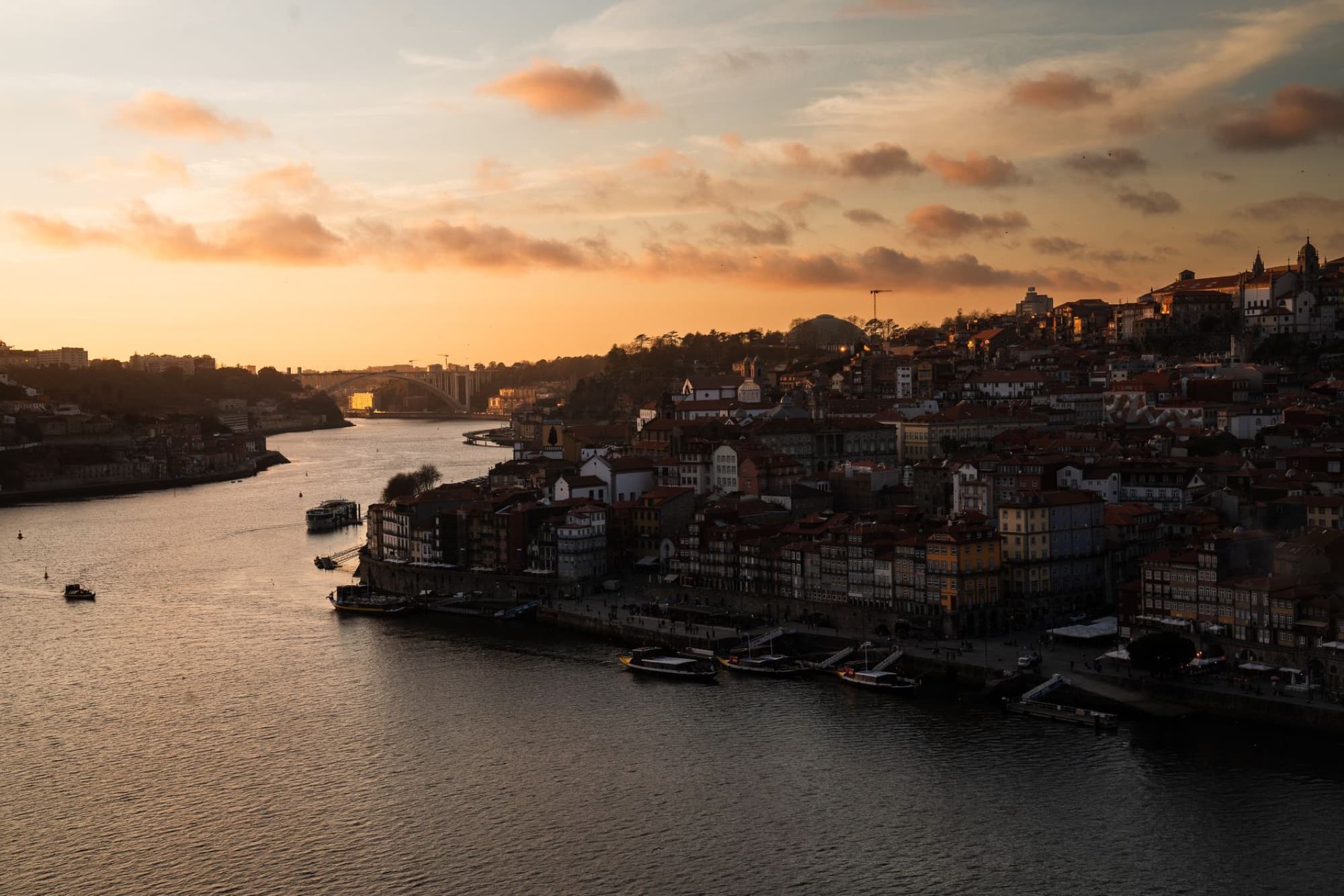 Stunning aerial sunset view of Porto, Portugal. Vibrant colors and serene Douro River with city skyline.
