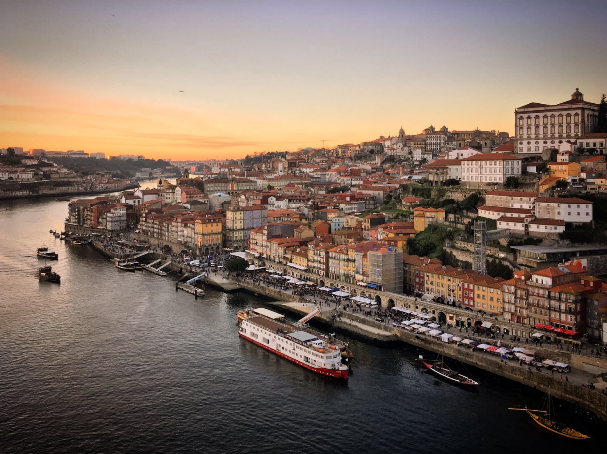 A breathtaking aerial view of Porto, Portugal at sunset, showcasing the scenic cityscape and the Douro River.