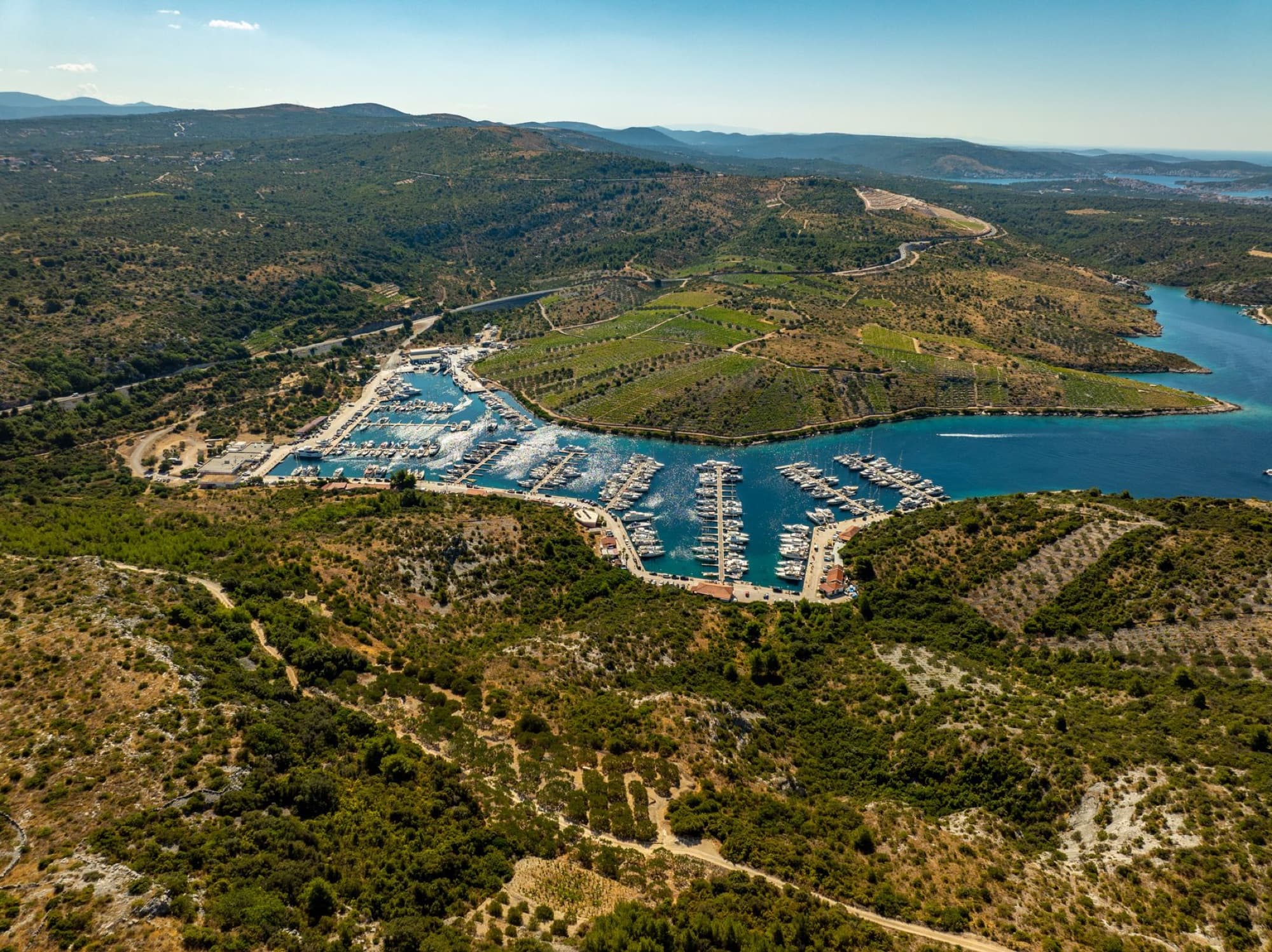 Stunning aerial photograph of a scenic marina in Primošten, Croatia, showcasing vibrant Mediterranean landscape.