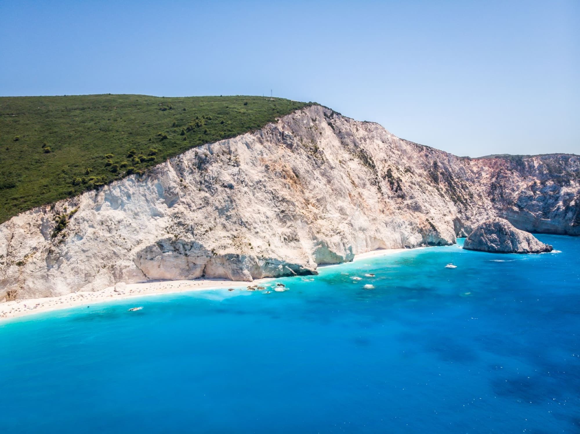 Breathtaking landscape of rocky cliff covered by green grass located on Porto Katsiki Beach washing by amazing azure sea water in Lefkada Island