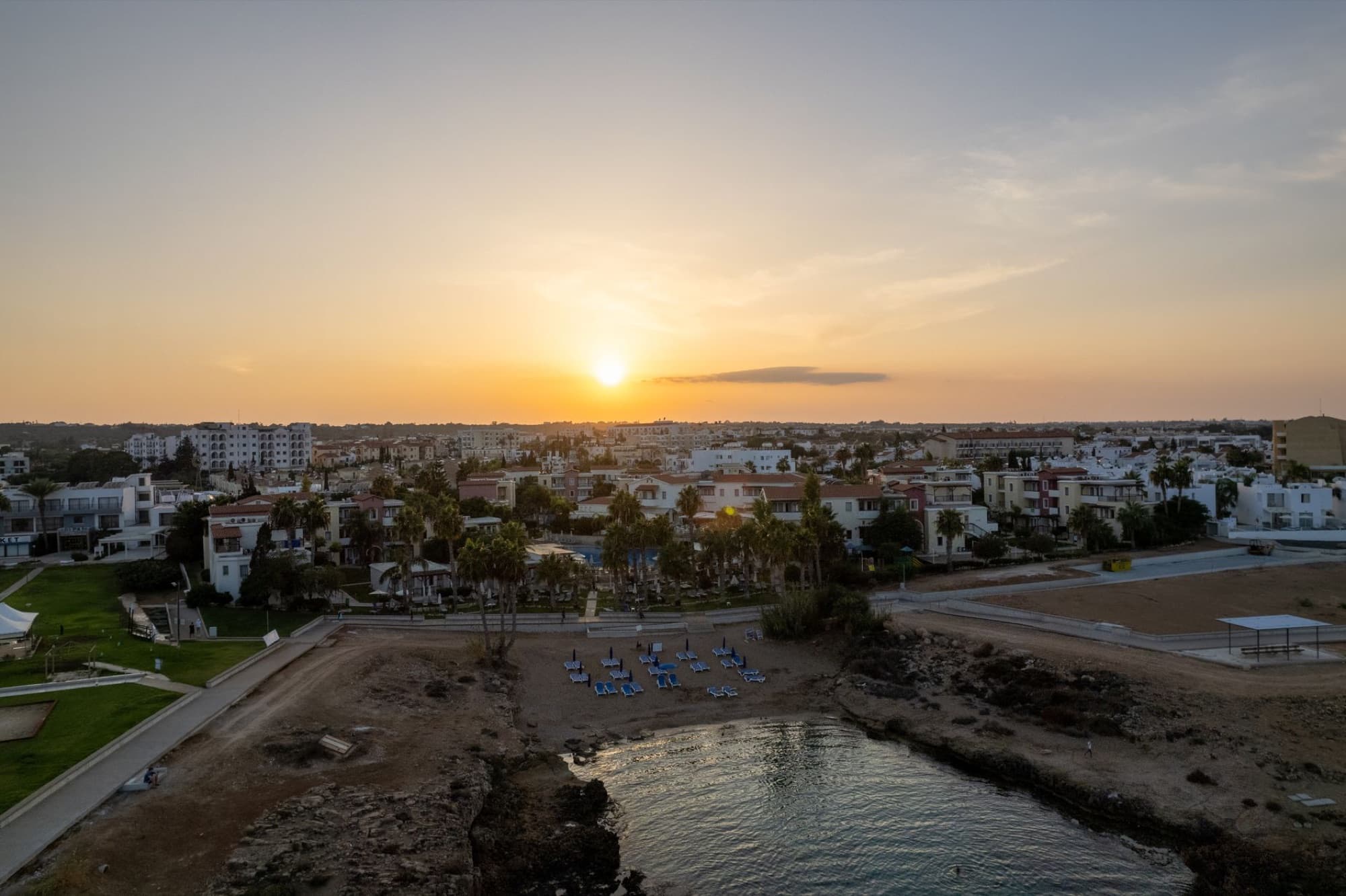 A breathtaking aerial view of Pernera, Cyprus at sunset with its beautiful coastline and vibrant town.