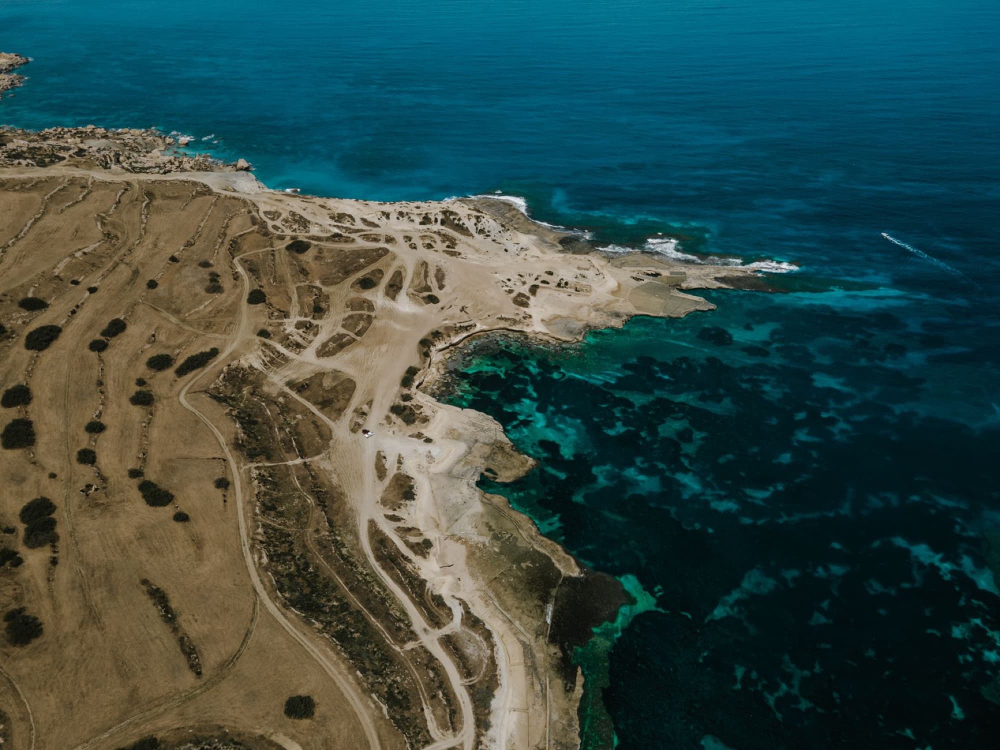 Drone shot of the stunning coastline of Mellieha, Malta showcasing turquoise waters and rugged cliffs.