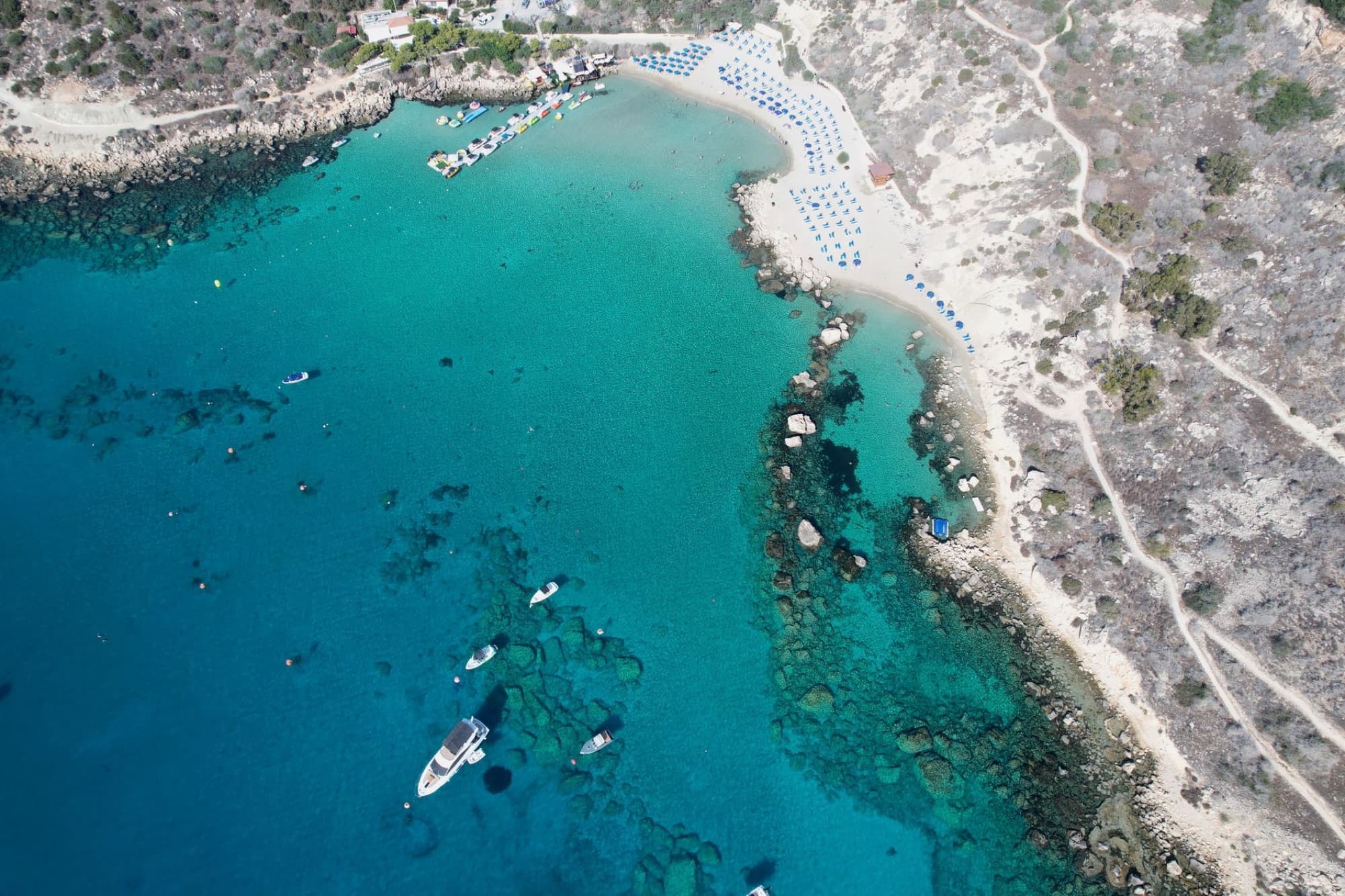 Stunning aerial view of turquoise waters and rocky coastline in Protaras, Cyprus.