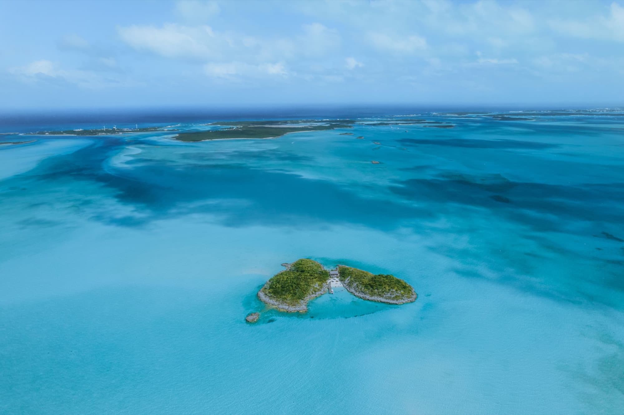 Breathtaking aerial view of a small island surrounded by calm turquoise waters.