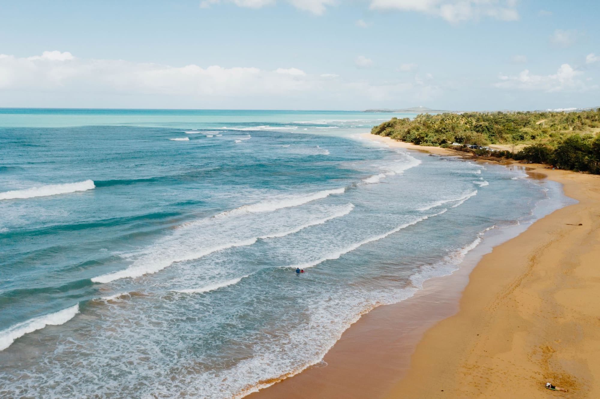 A stunning aerial shot of a beach in Puerto Rico, showcasing waves and lush greenery.