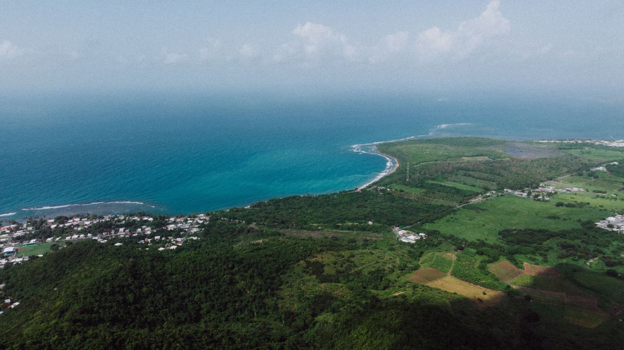 Stunning aerial view of Patillas, Puerto Rico coast with lush fields and clear sea, ideal for travel and nature lovers.