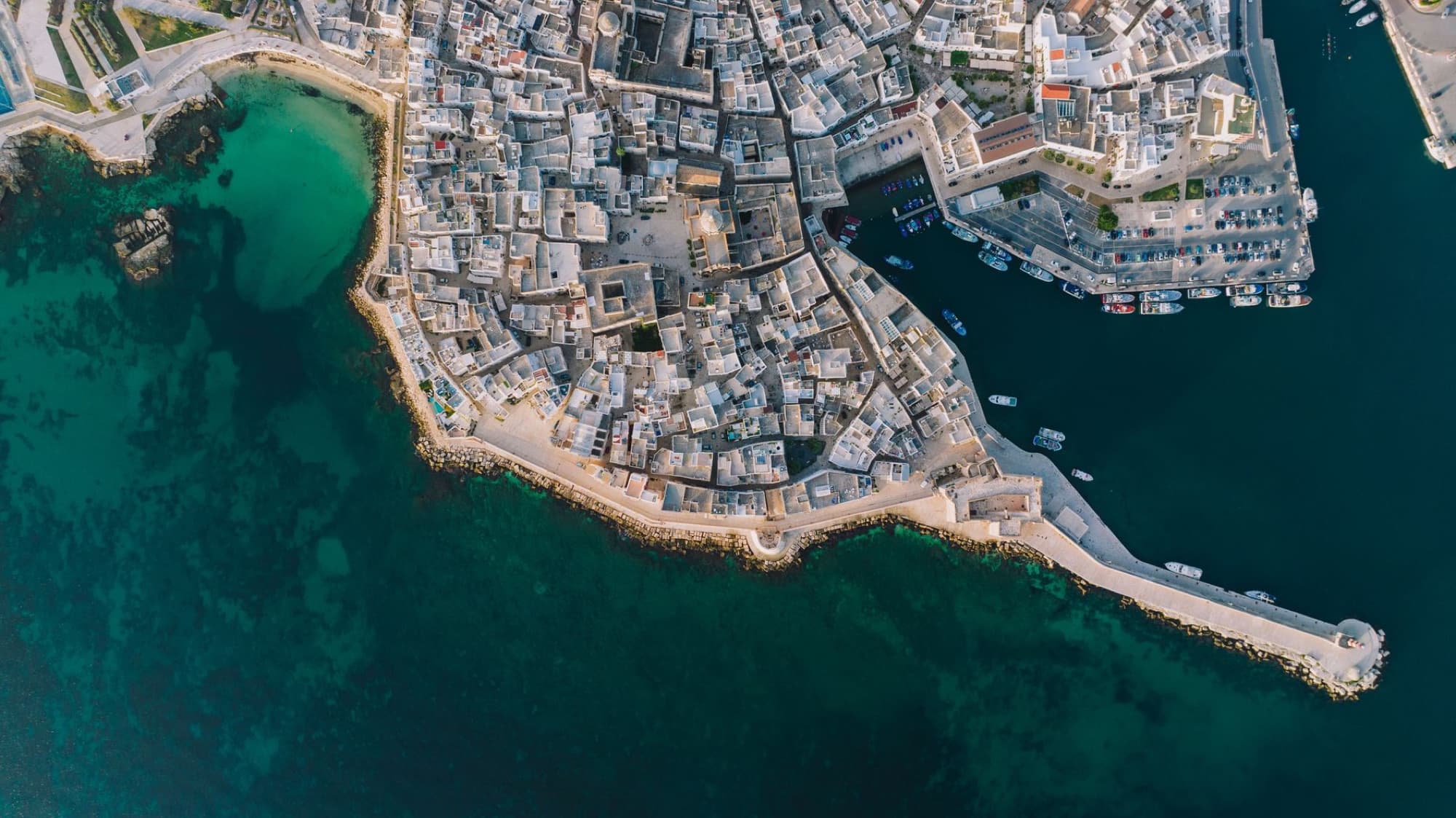 Stunning aerial view of Monopoli's coastline in Puglia, Italy. Sunlit architecture meets turquoise seas.