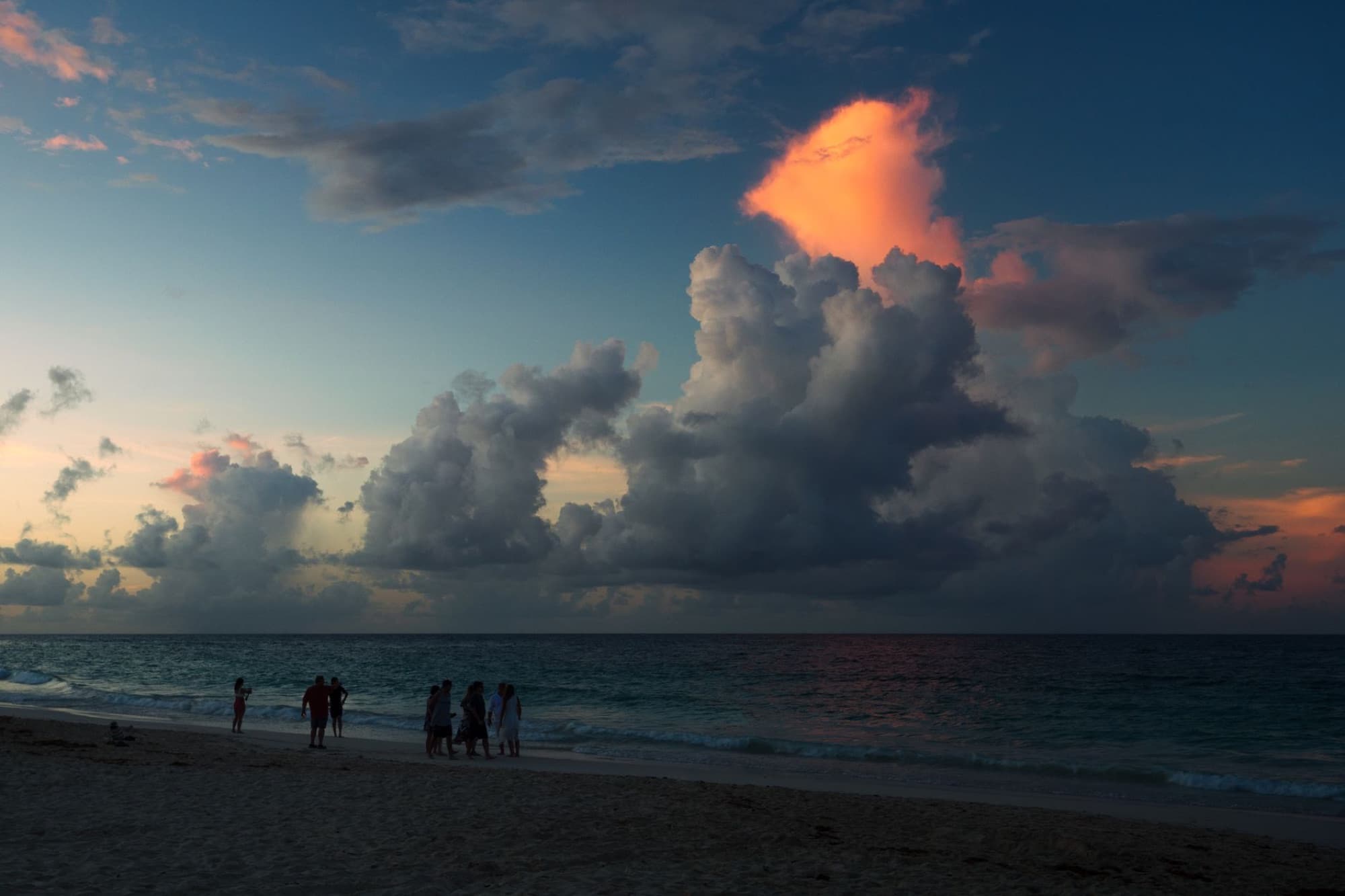 A scenic beach view with dramatic clouds and sunset hues in Punta Cana, Dominican Republic.