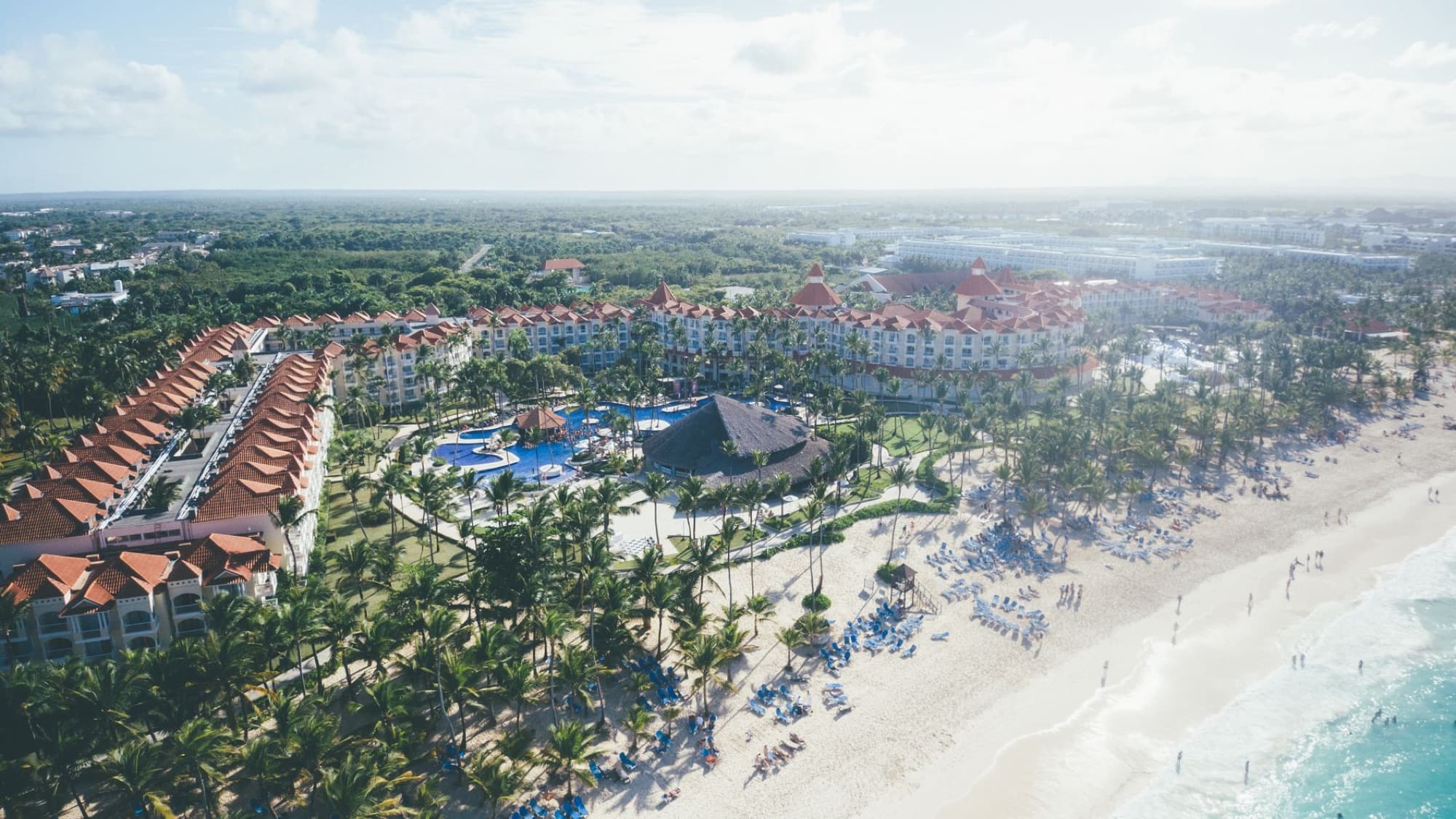Aerial shot of a tropical beach resort in Punta Cana with palm trees and ocean views.