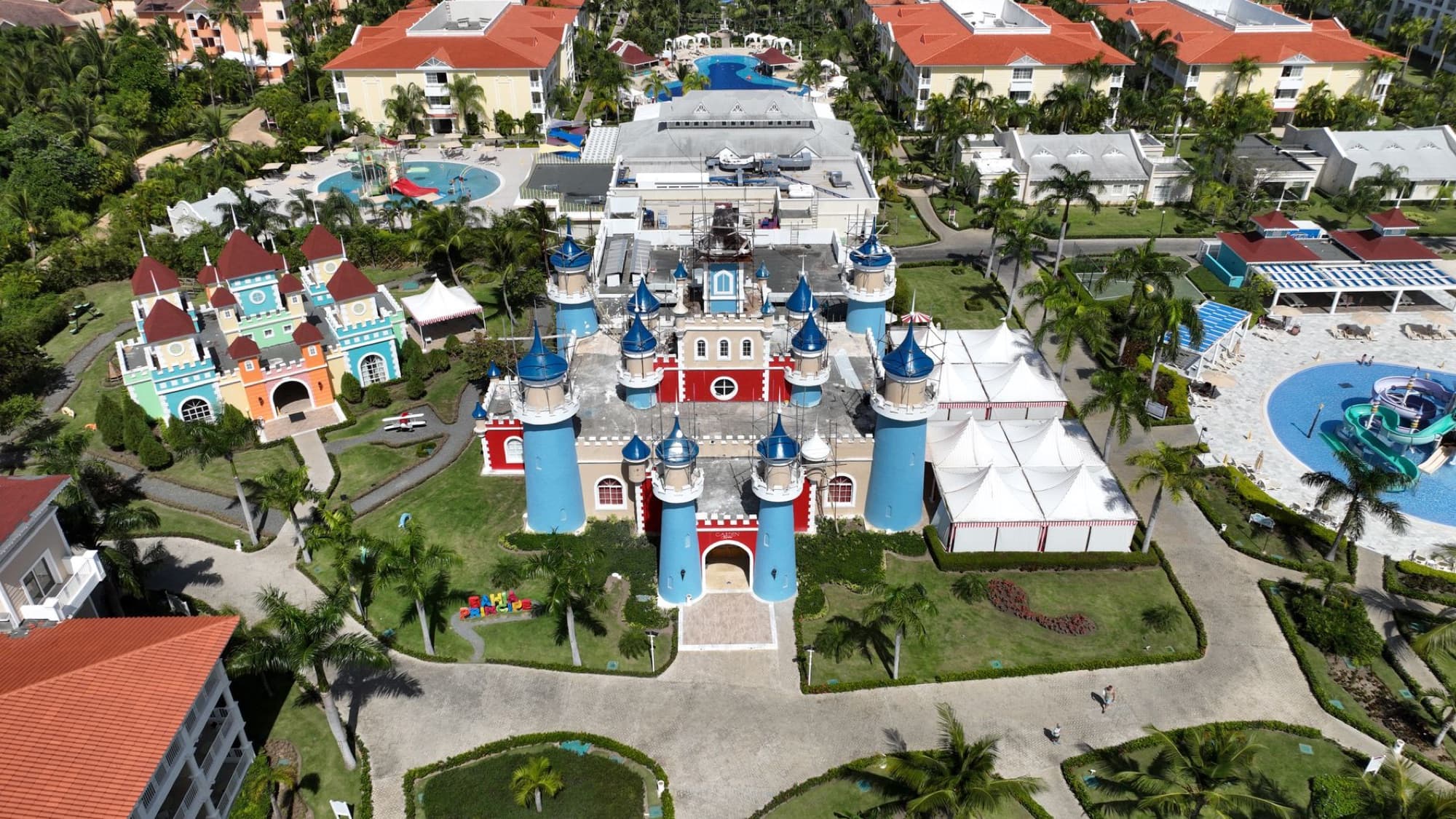 Explore a colorful resort landscape with castles and pools from above in Punta Cana.