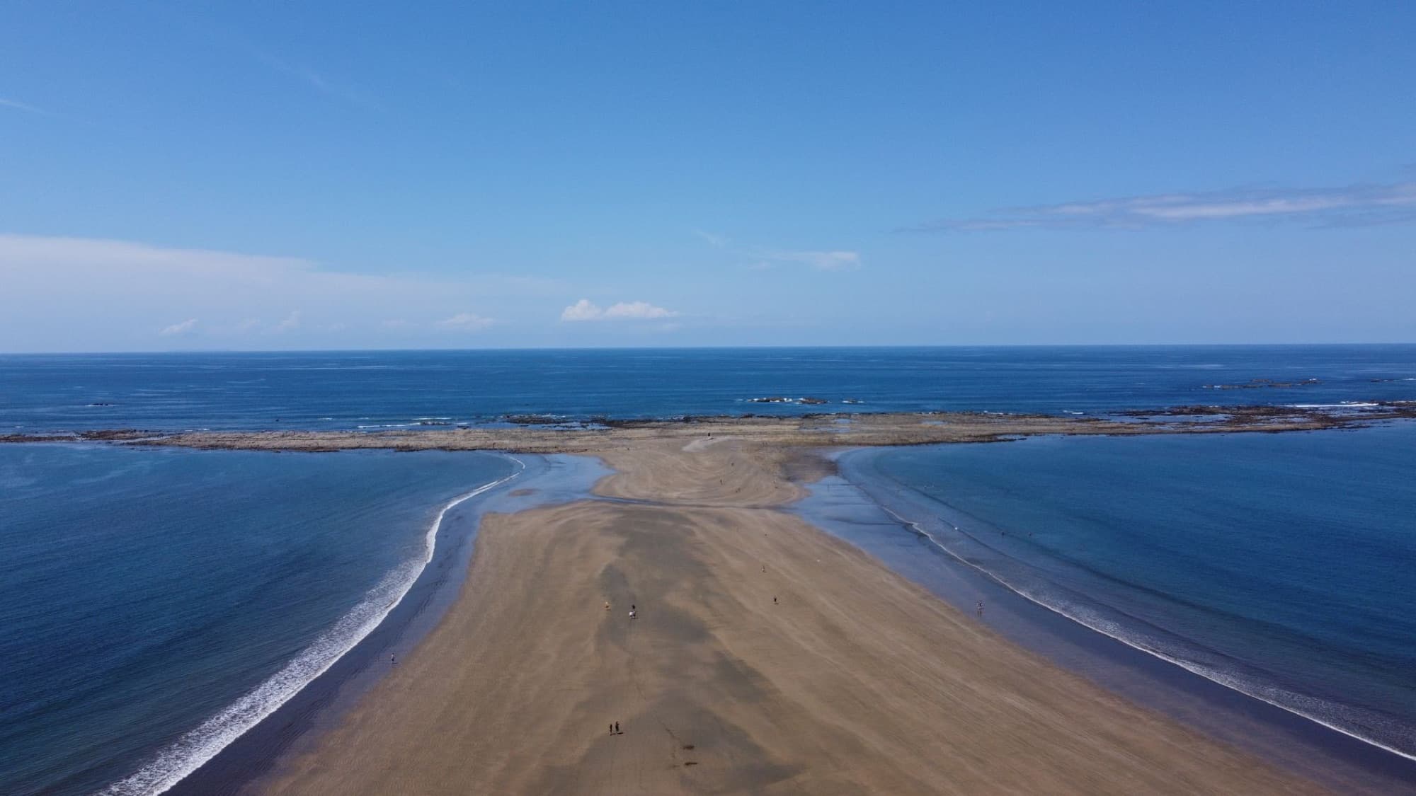 Stunning aerial view of Ballena Beach in Puntarenas, Costa Rica with clear blue skies and ocean.