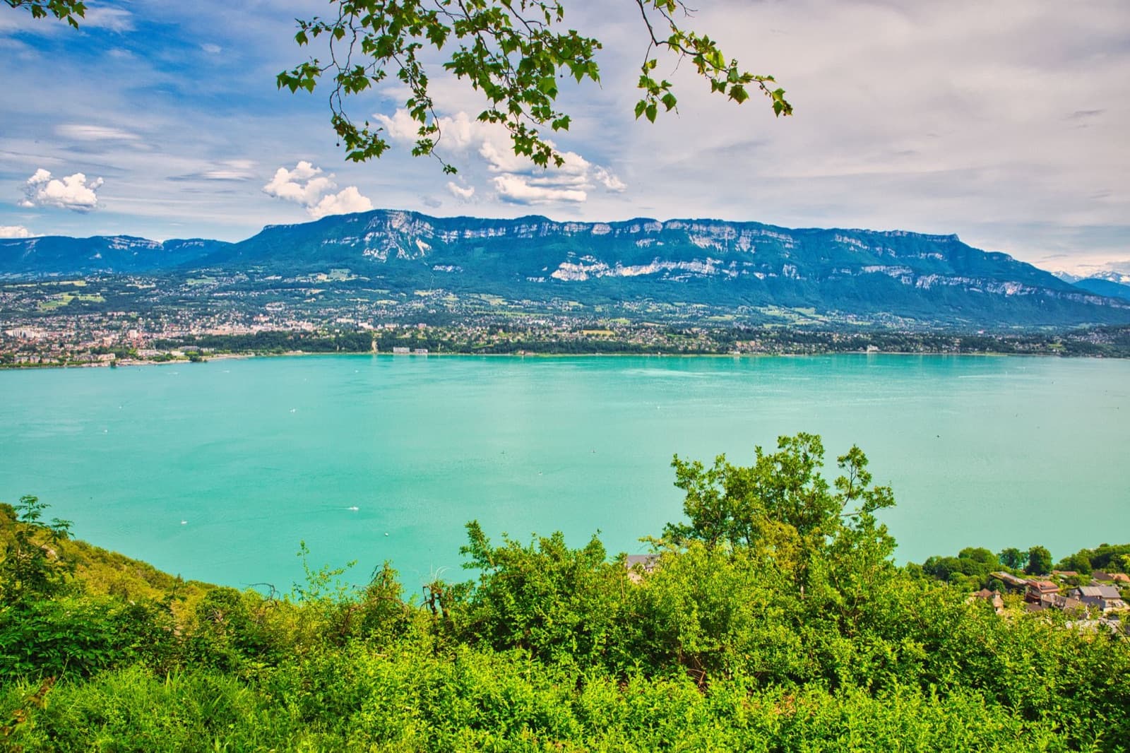 Experience the tranquil beauty of Lake Bourget surrounded by the majestic French Alps in Auvergne-Rhône-Alpes, France.