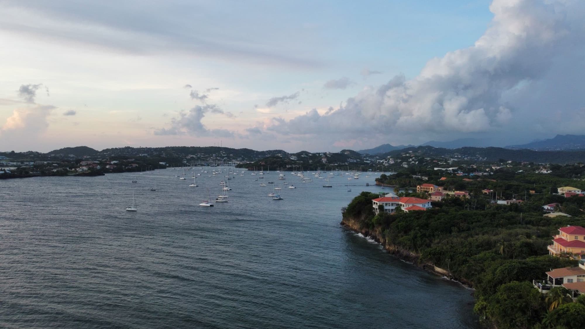 A picturesque aerial view of boats anchored in a scenic coastal bay at twilight.