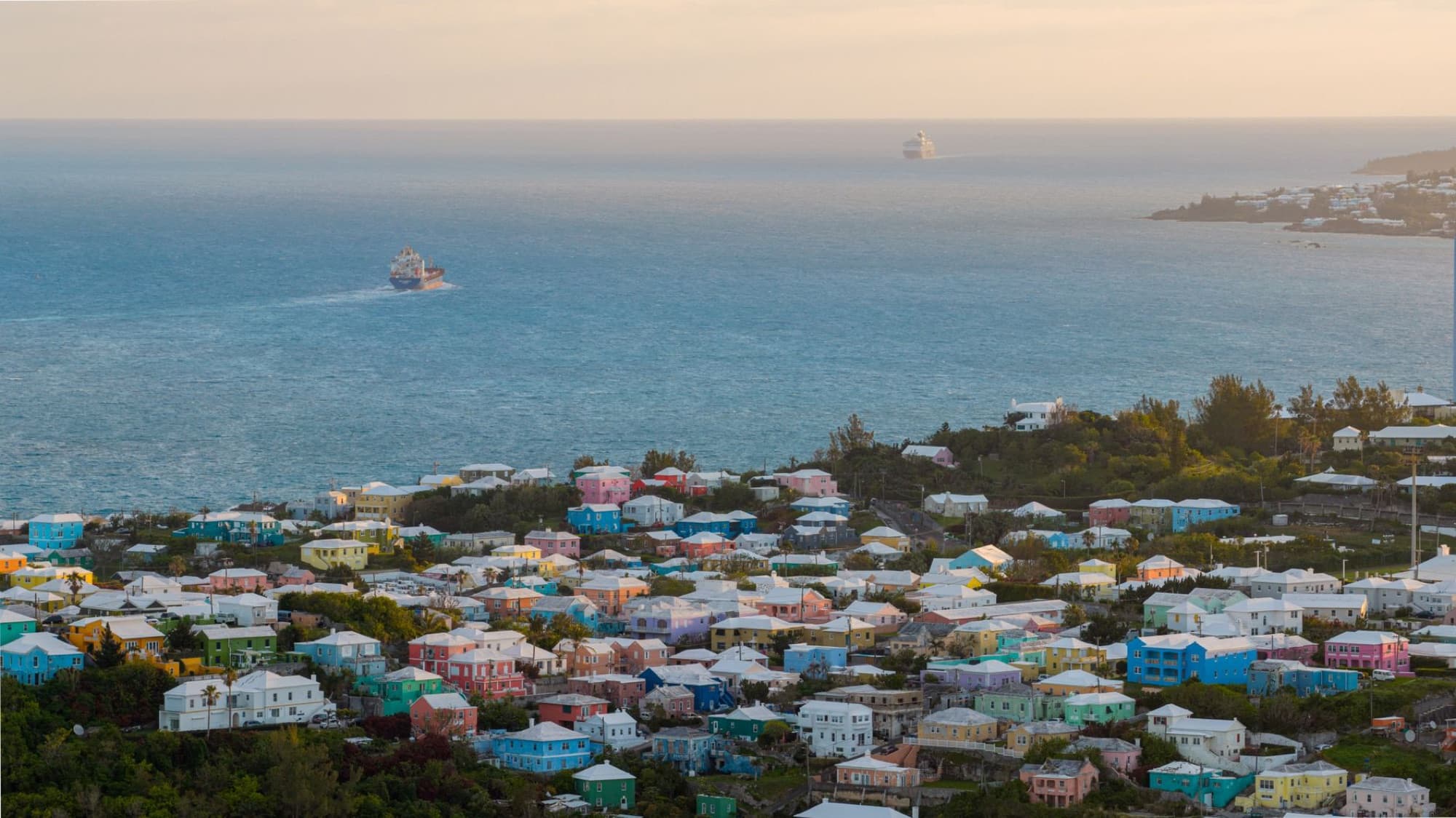 Stunning aerial view of Bermuda's colorful houses along the Atlantic Ocean at sunrise.