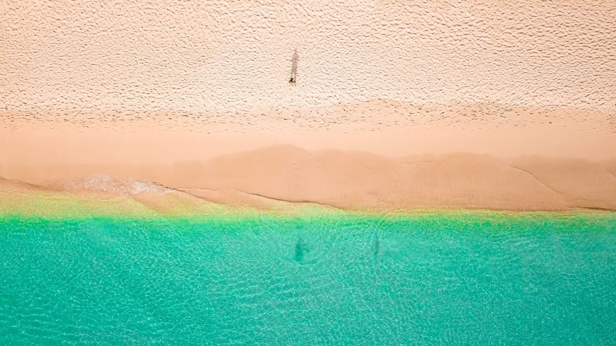 A breathtaking drone shot of Holetown Beach, Barbados, showcasing turquoise waters and golden sand.