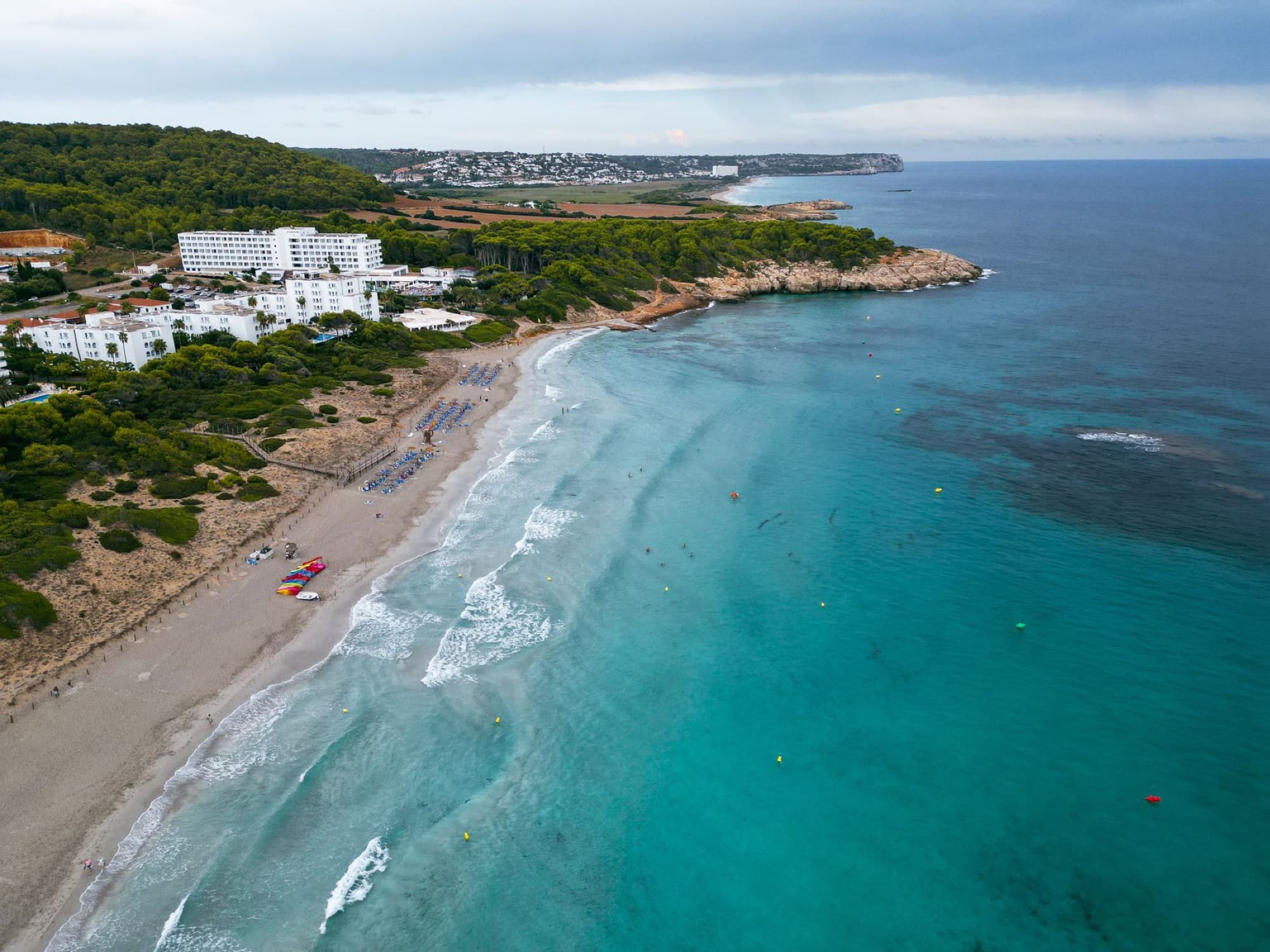 Stunning aerial view of Sant Tomas Beach, Spain, showcasing turquoise waters and scenic coastline.