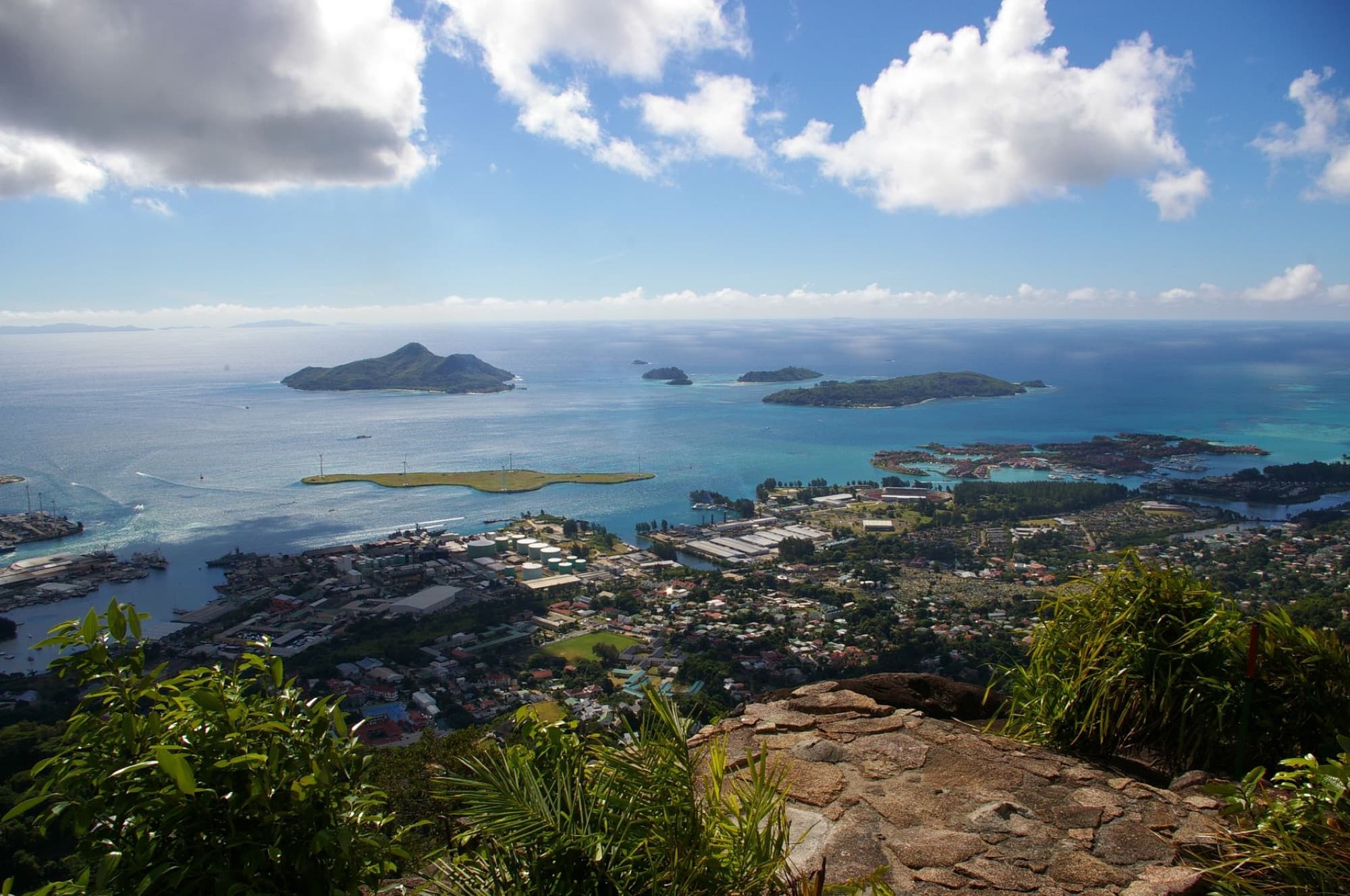 Stunning aerial landscape of Seychelles islands and ocean from a mountain viewpoint under a bright sky.