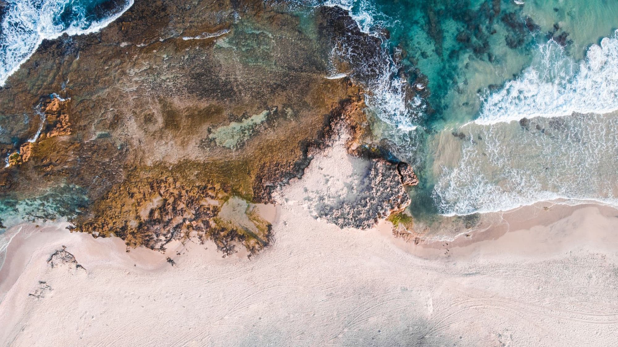 Stunning aerial photo of a coastal beach in Israel, showcasing clear waters and sandy shoreline.