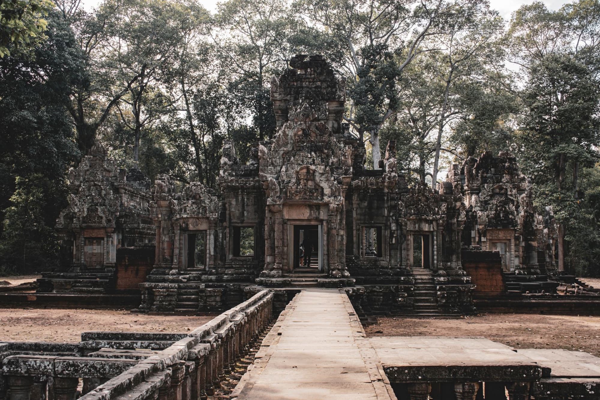 Explore the serene beauty of an ancient Cambodian temple set amidst lush greenery in Siem Reap.