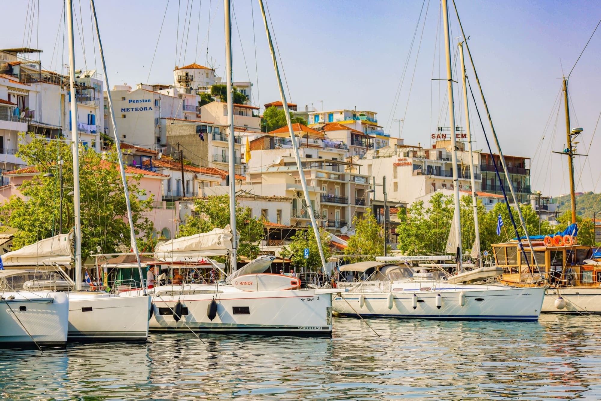 Scenic view of moored yachts at the charming Skiathos harbor under a clear sky.