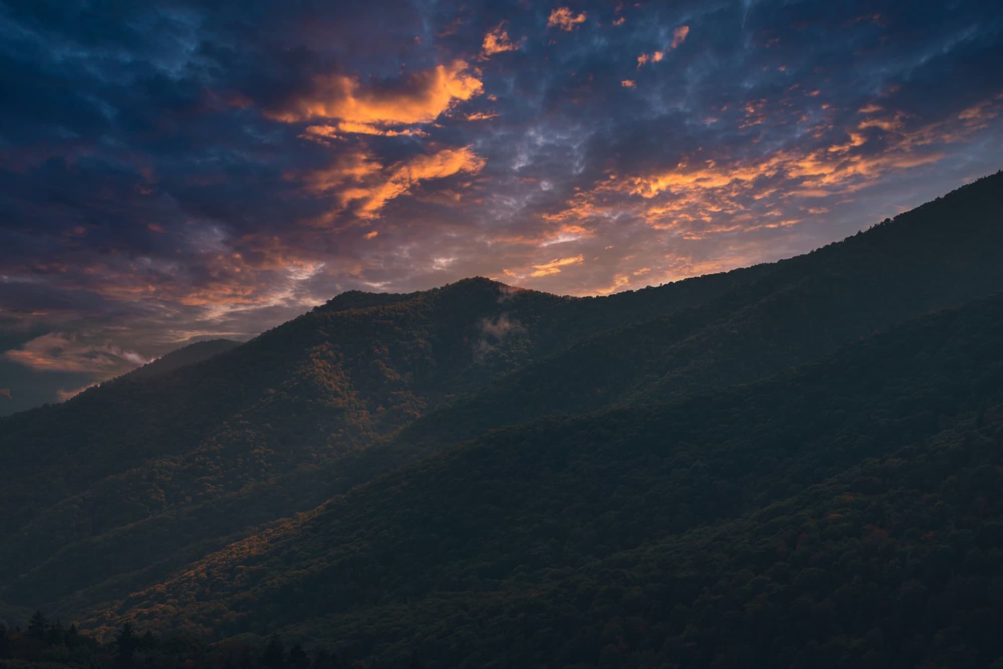 Breathtaking sunset over the Smoky Mountains with vivid skies and silhouetted peaks.