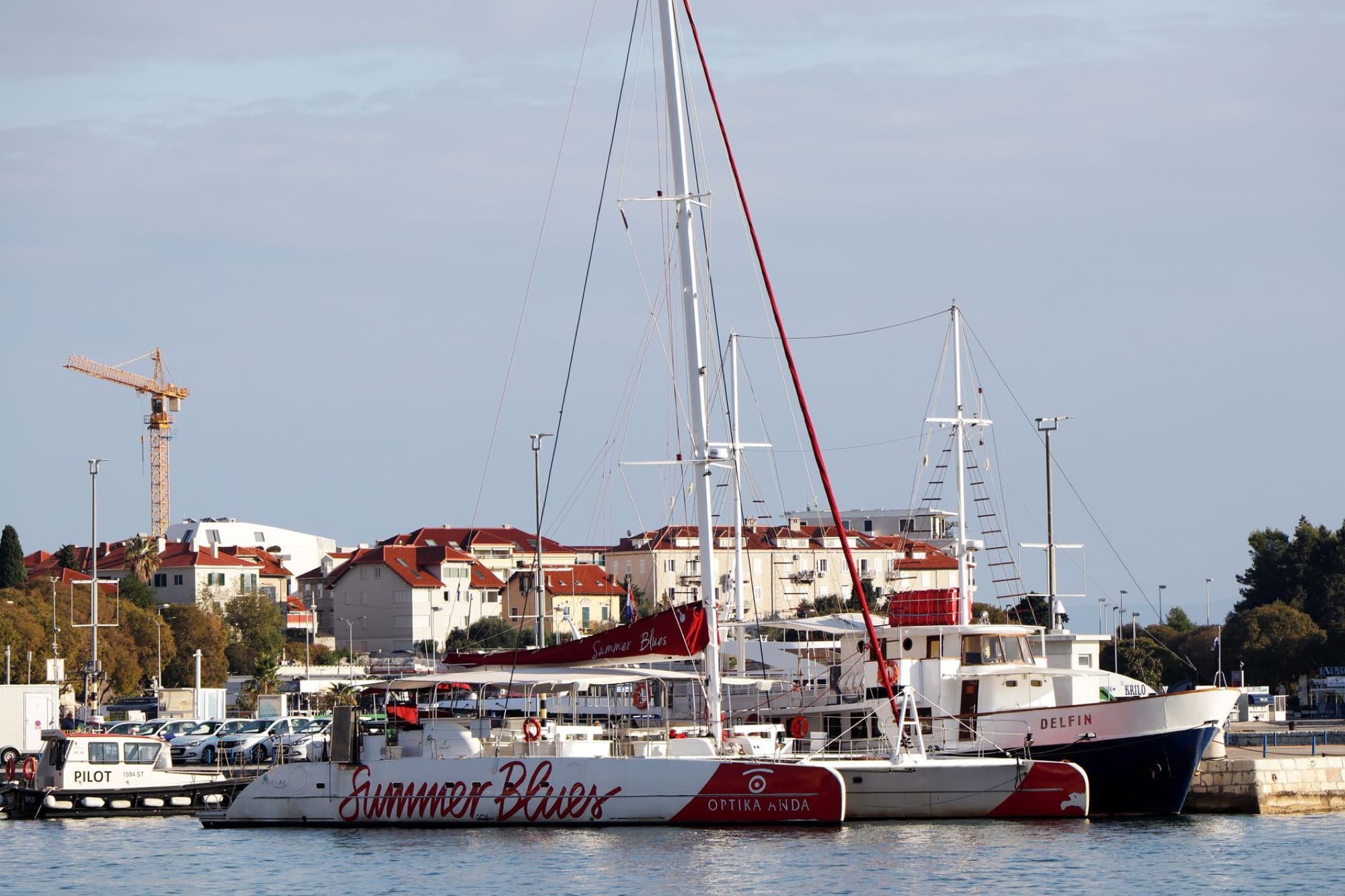 Scenic view of catamarans and yachts docked in Split Harbor, Croatia, on a sunny day.
