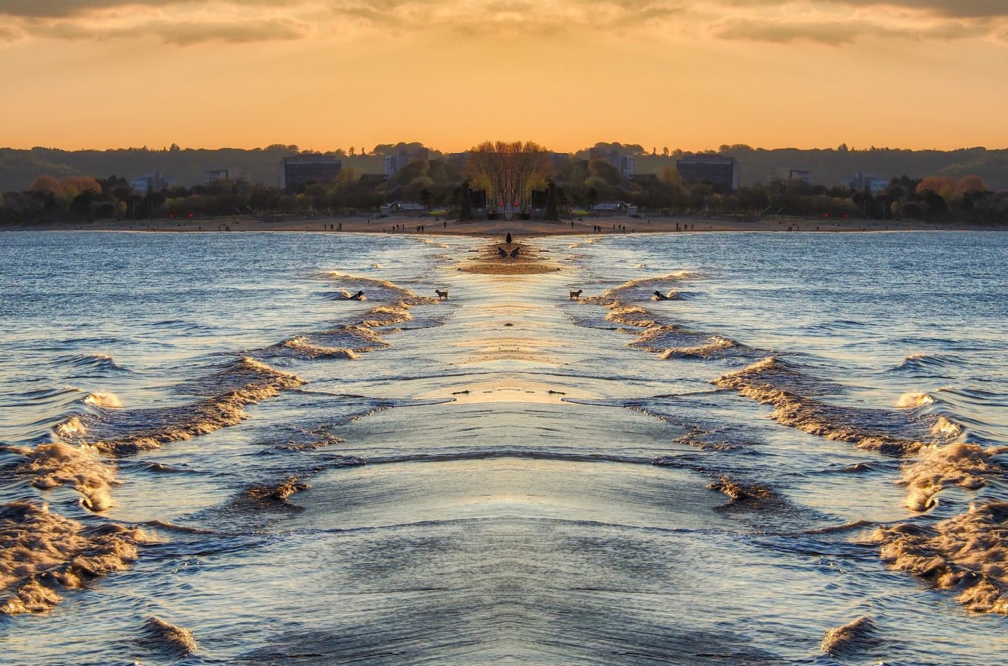 Stunning sunset view of Swansea Bay beach with gentle waves and golden hues in Wales.
