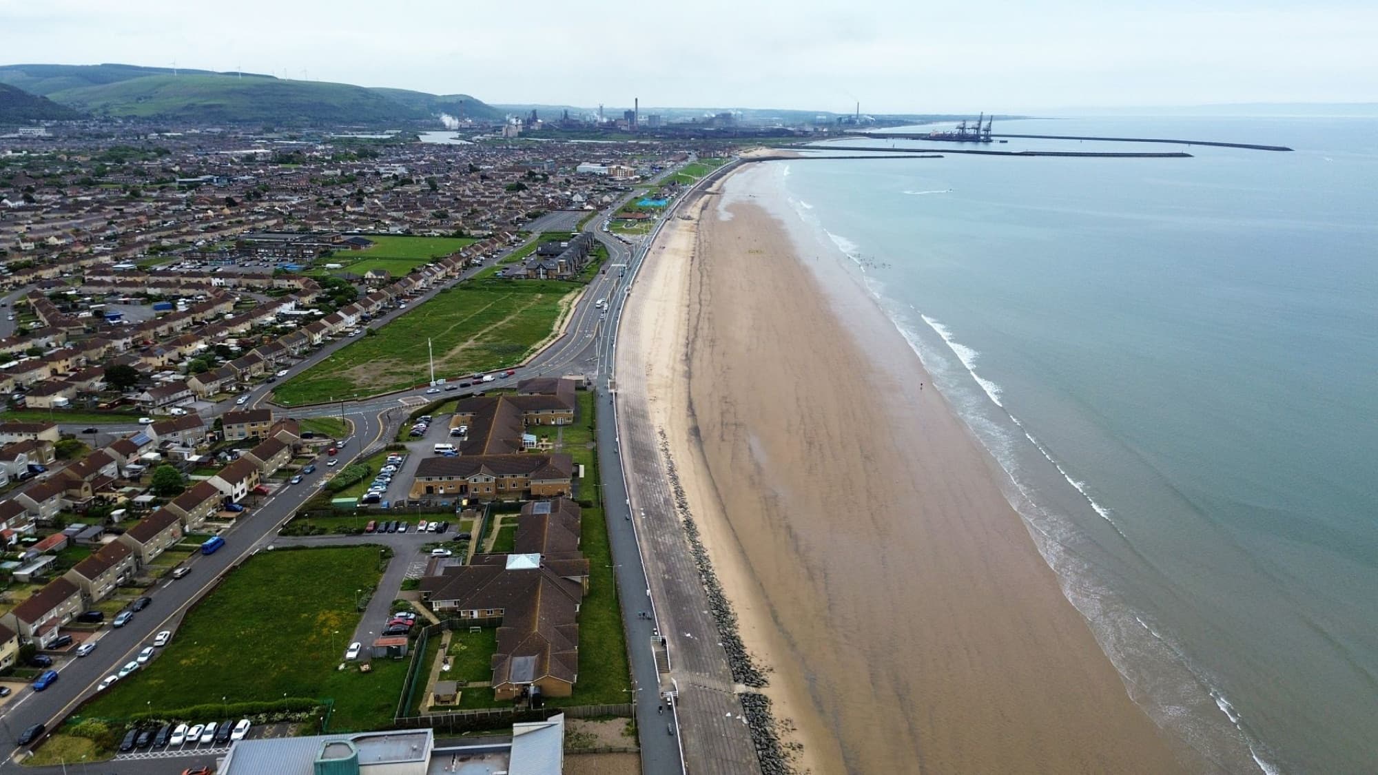 Aerial shot of Aberavon Beach and Port Talbot in Wales, showcasing the coastline and urban landscape.