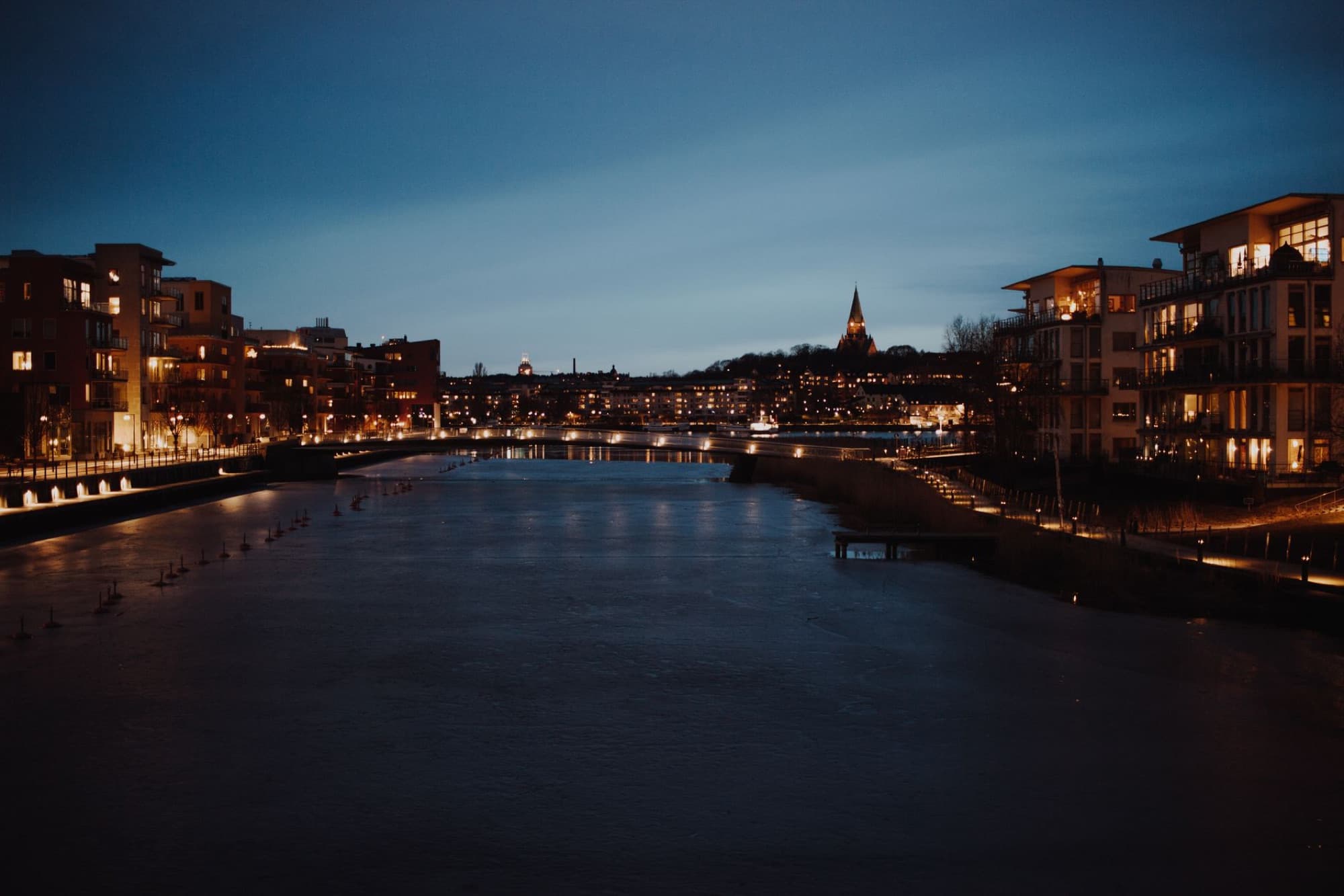 Evening view of Södermalm's illuminated waterfront buildings and skyline in Stockholm, Sweden.