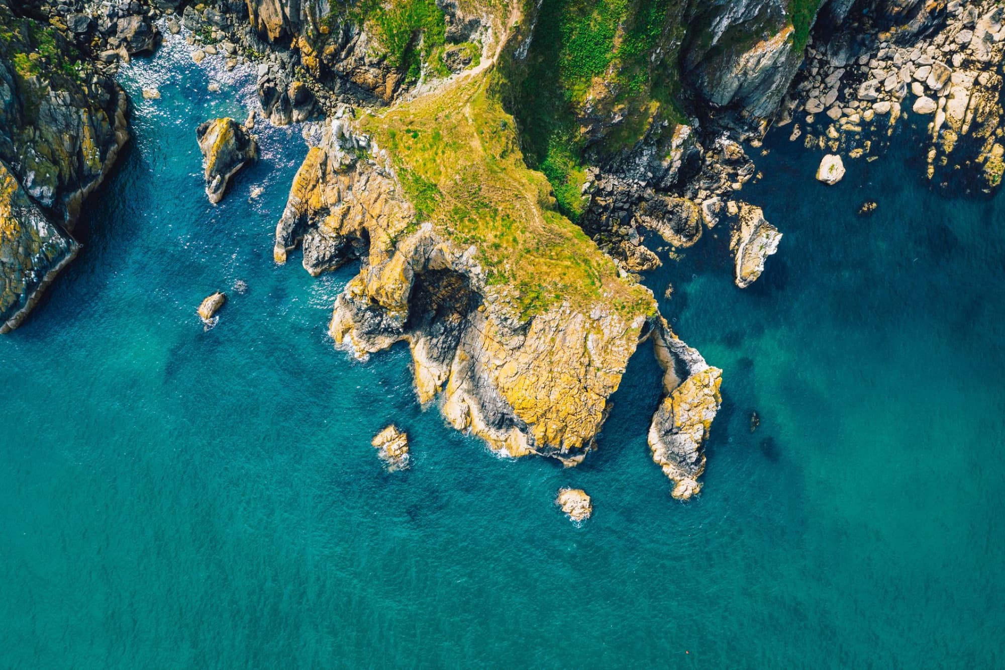 A breathtaking aerial view of Dublin's rugged coastline with vibrant blue waters and rocky cliffs.