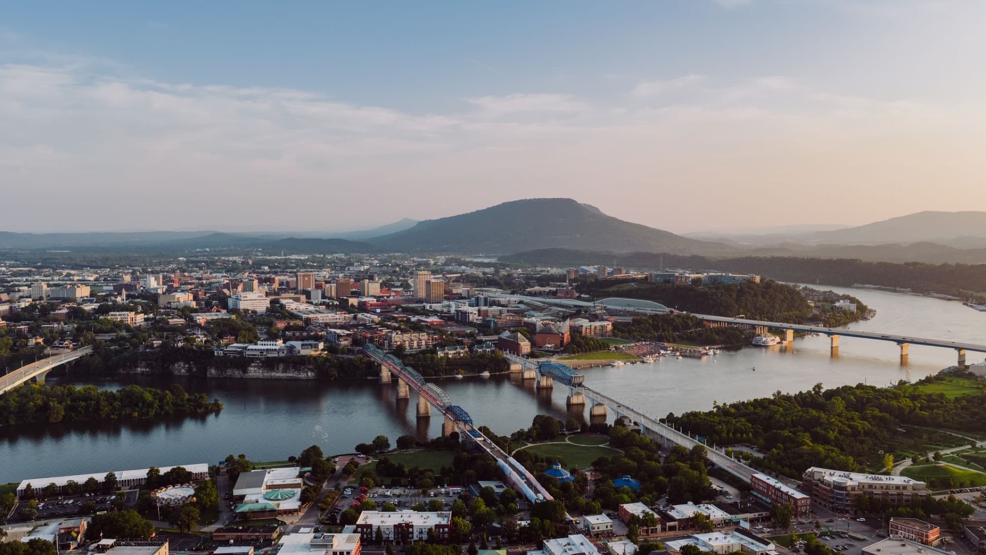 Breathtaking aerial view of Chattanooga, Tennessee skyline with iconic bridges and river at sunset.