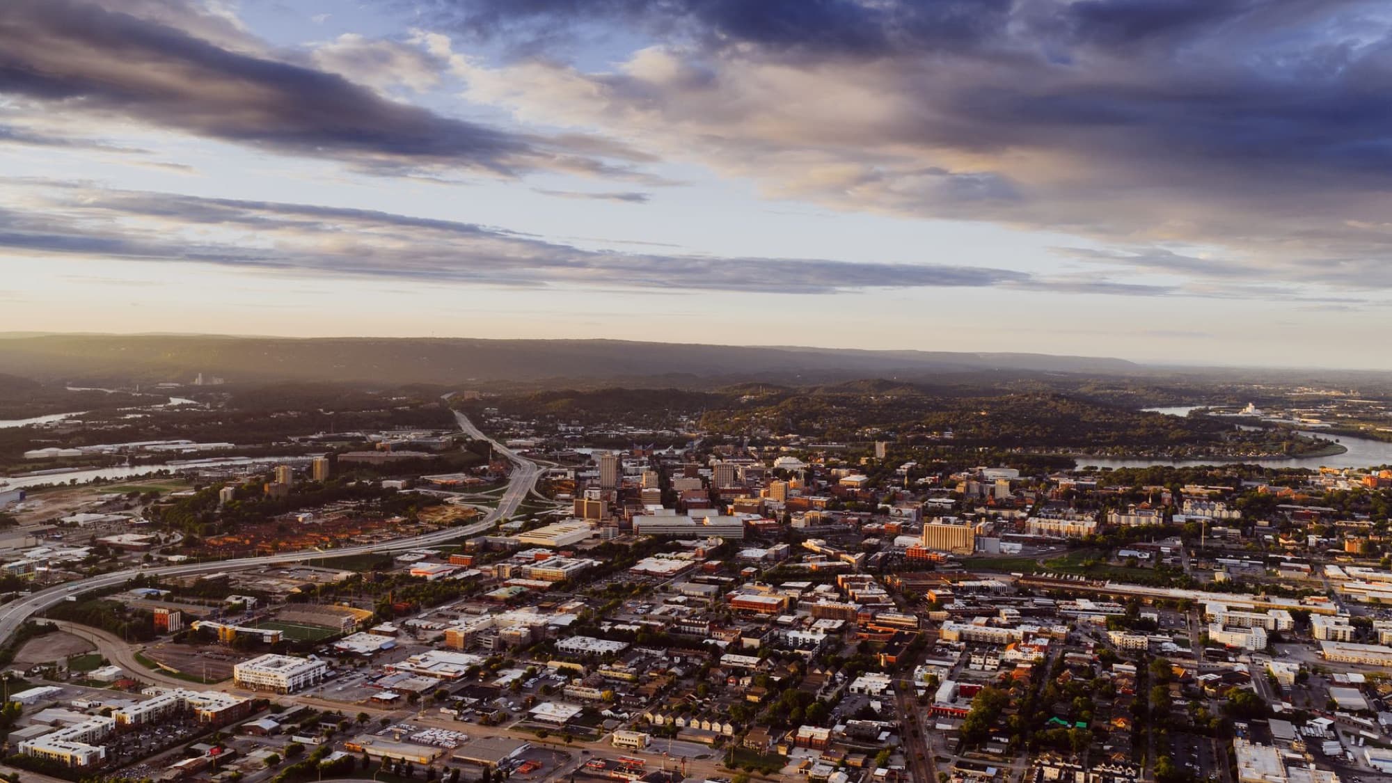 Stunning aerial view of Chattanooga, Tennessee with scenic hills and Tennessee River during sunset.