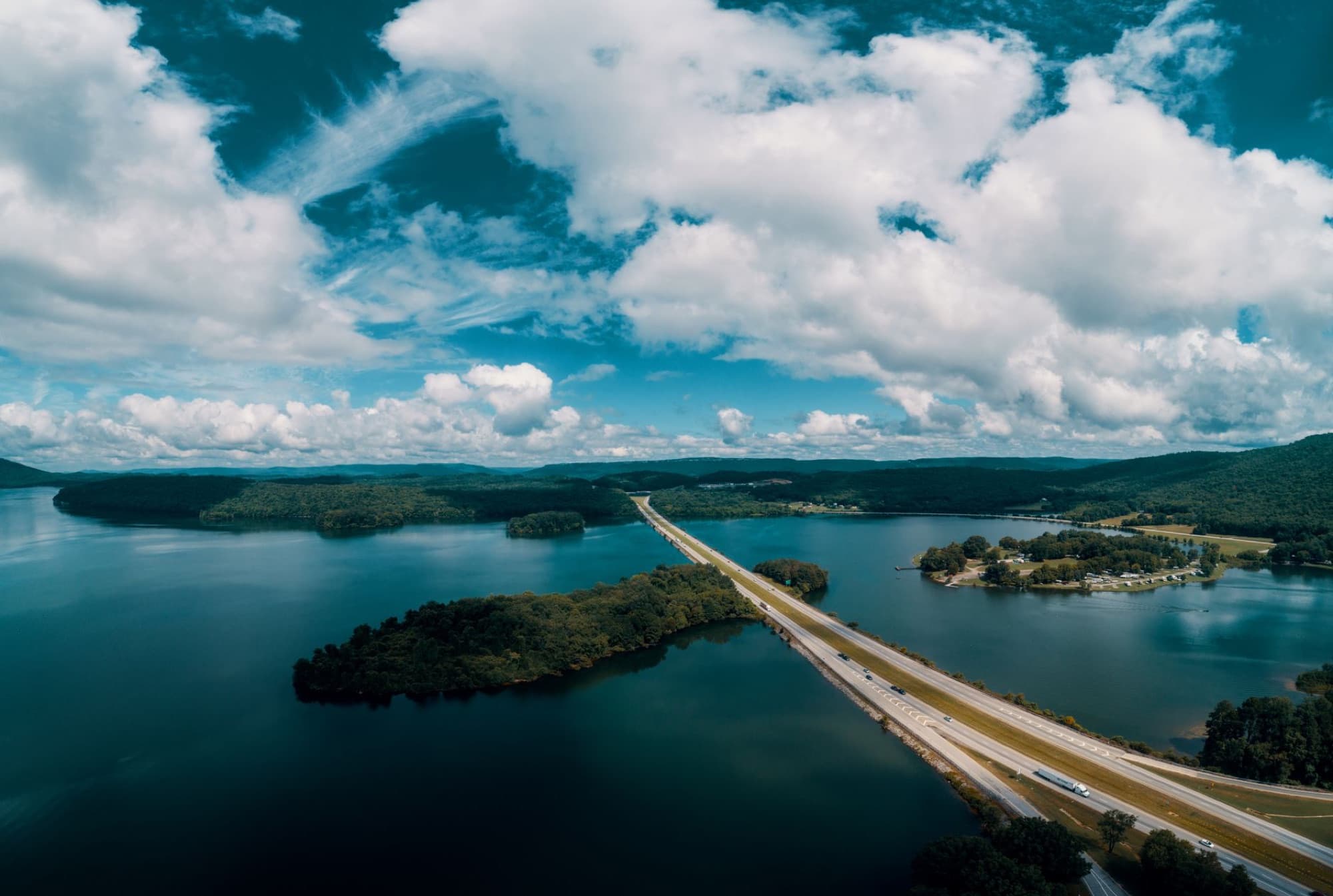 Aerial view of a highway crossing over a scenic lake in Jasper, Tennessee, under a cloudy sky.