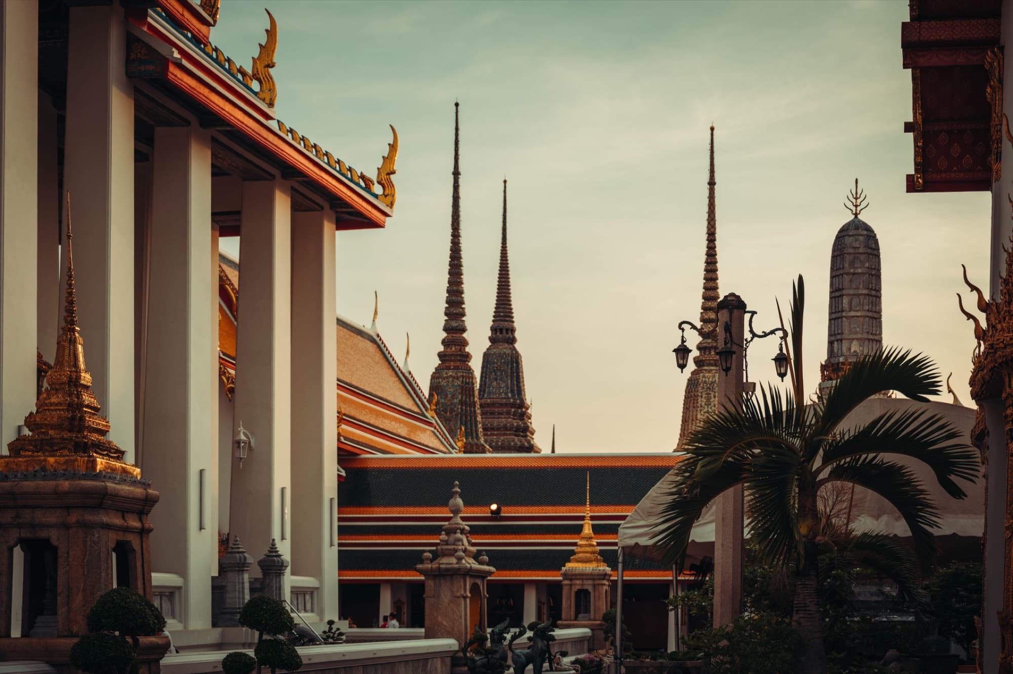 Stunning view of Wat Pho's ornate spires in Bangkok, Thailand at sunset.