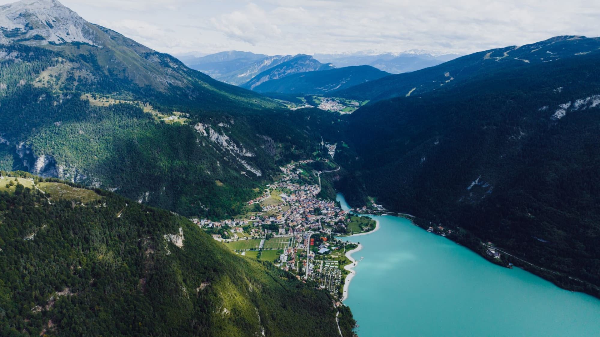 Breathtaking aerial view of Molveno Lake and village surrounded by mountains in Trentino-Alto Adige, Italy.