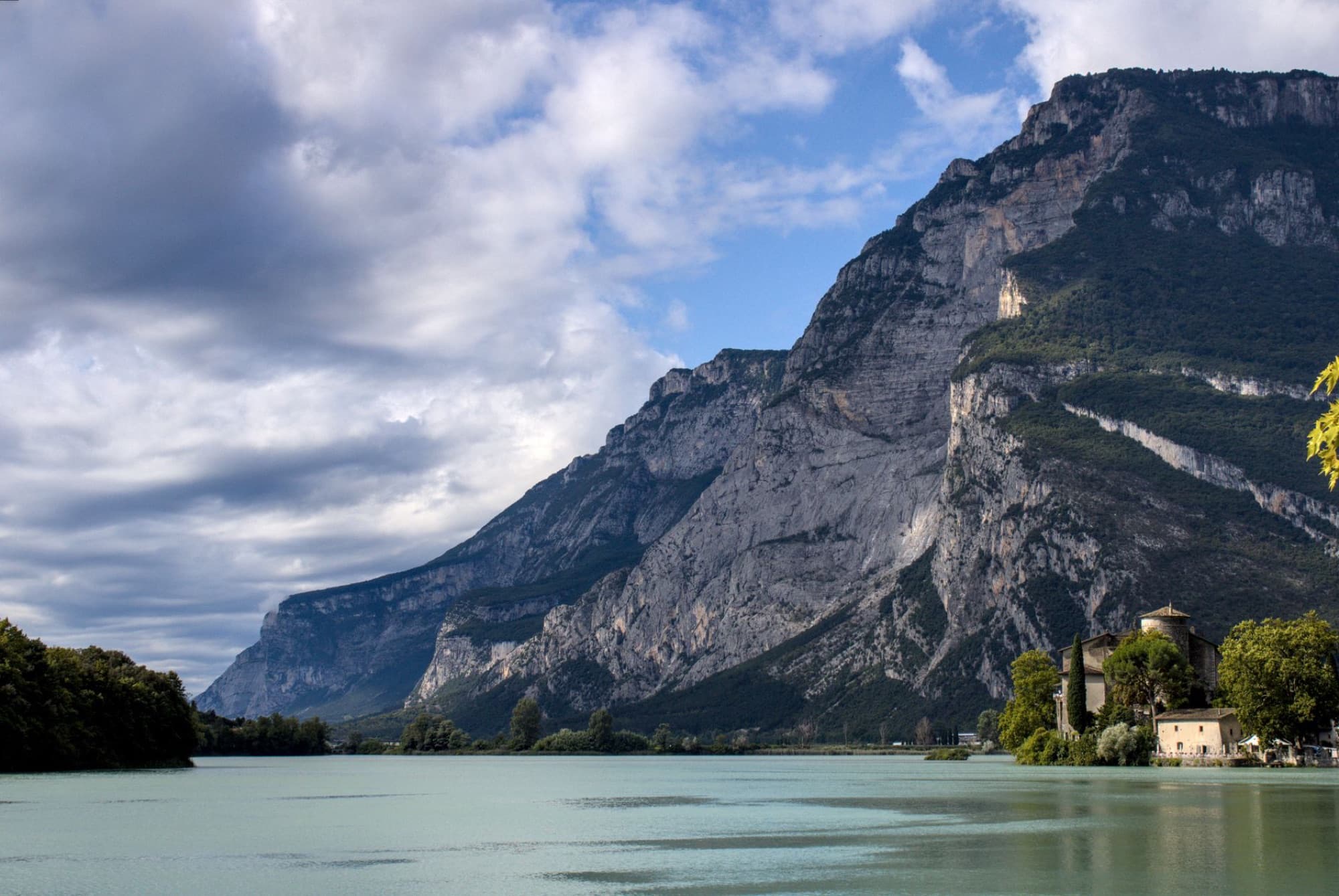 A beautiful landscape of a lake with surrounding mountains and a castle, showcasing nature's splendor.