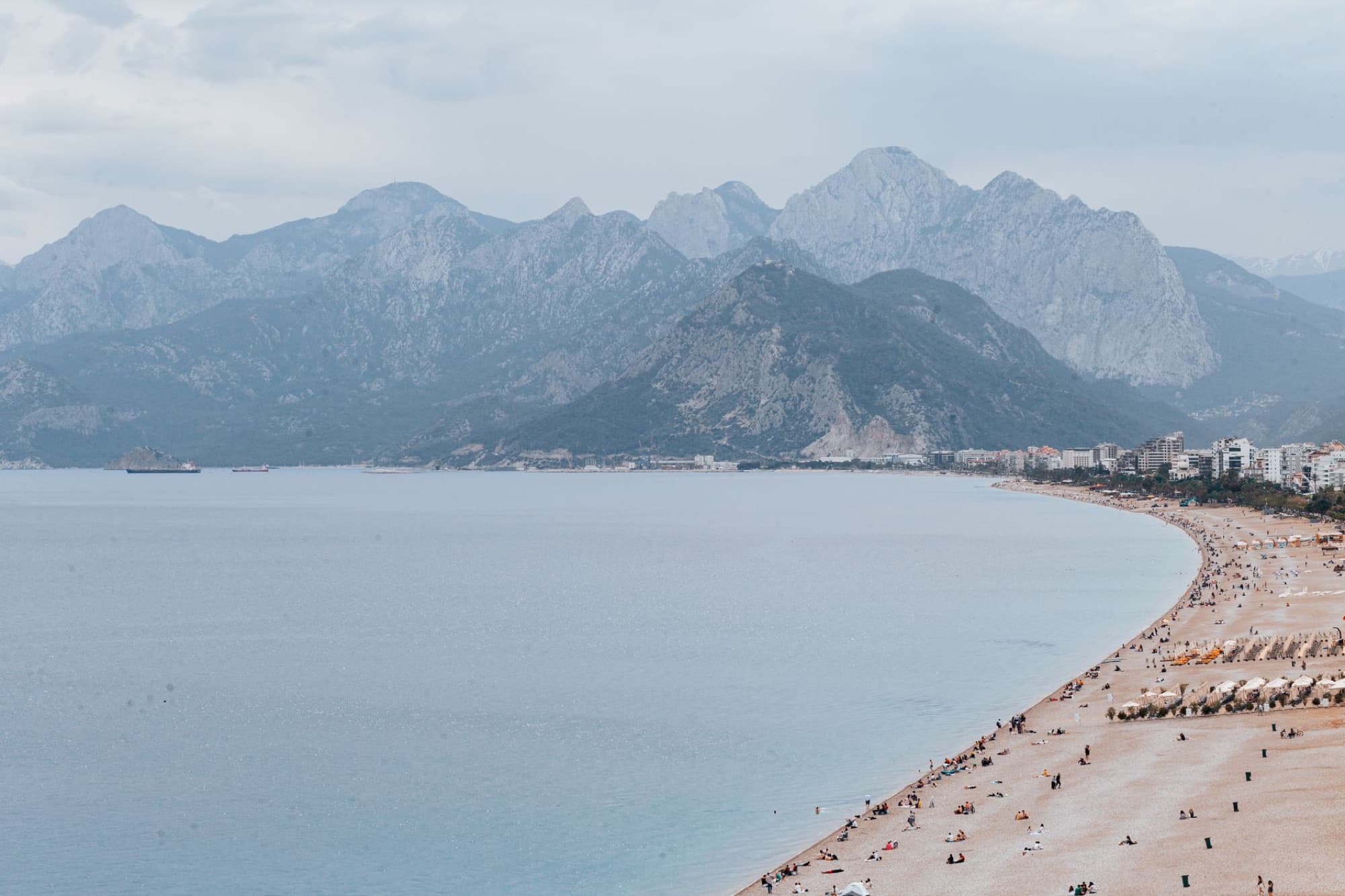 A stunning aerial view of Antalya's coastline with its beautiful beach and majestic mountains.