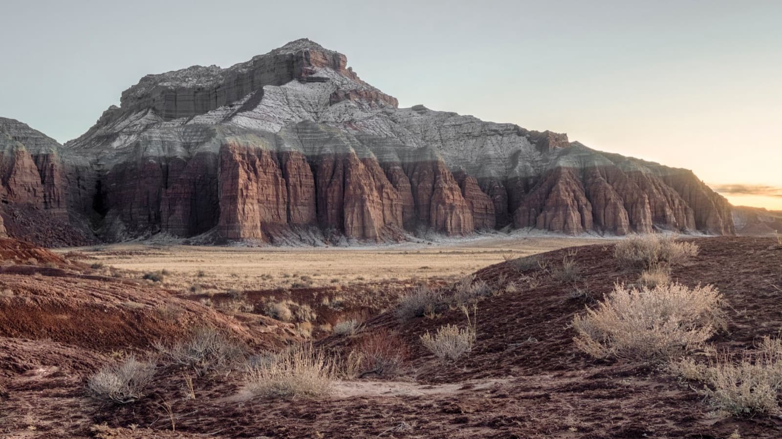 Explore the breathtaking Cathedral Valley with its towering rock formations at sunrise in Utah's desert landscape.